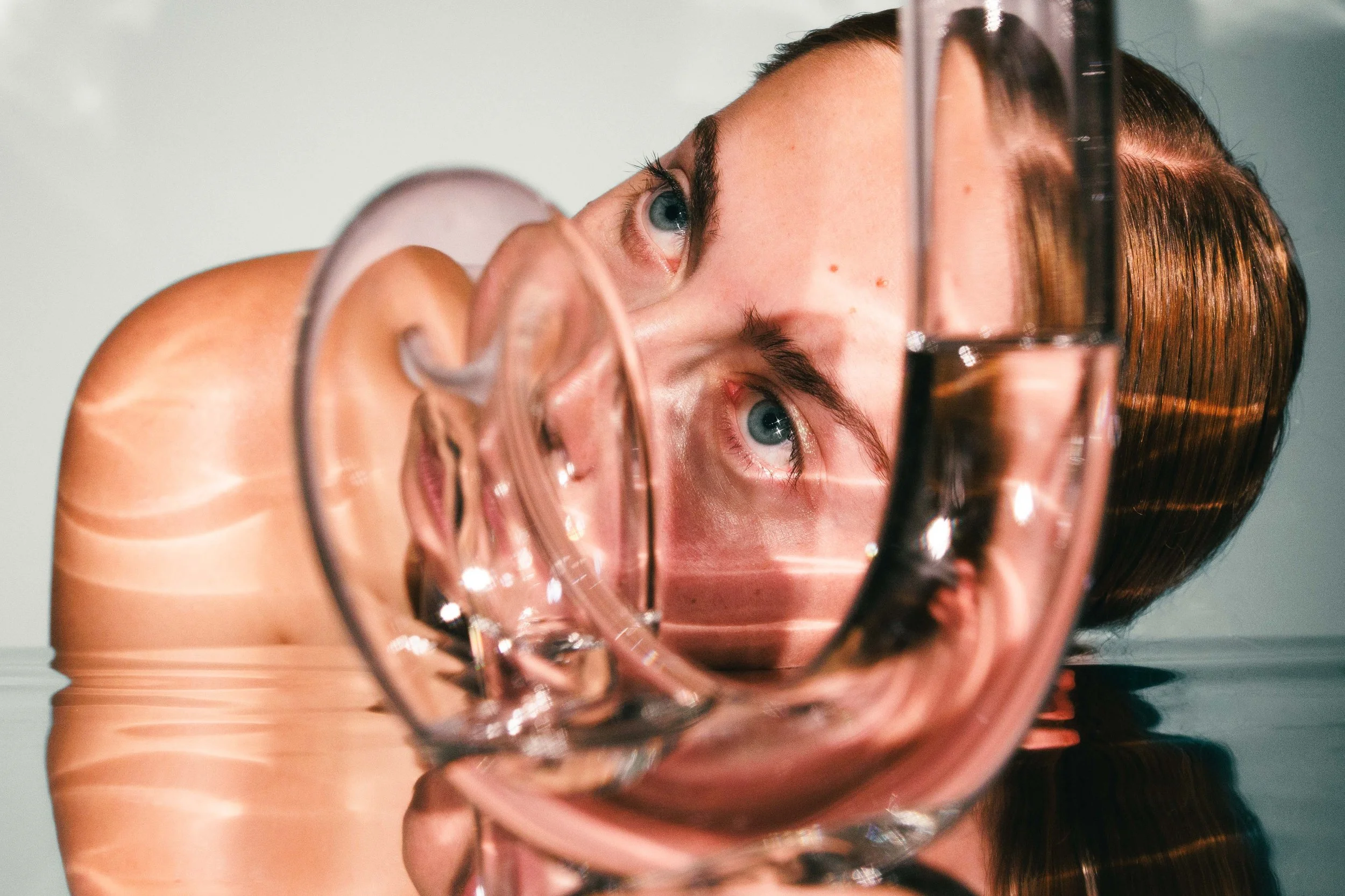 Commercial lifestyle photo of a young woman with reflective glassware.