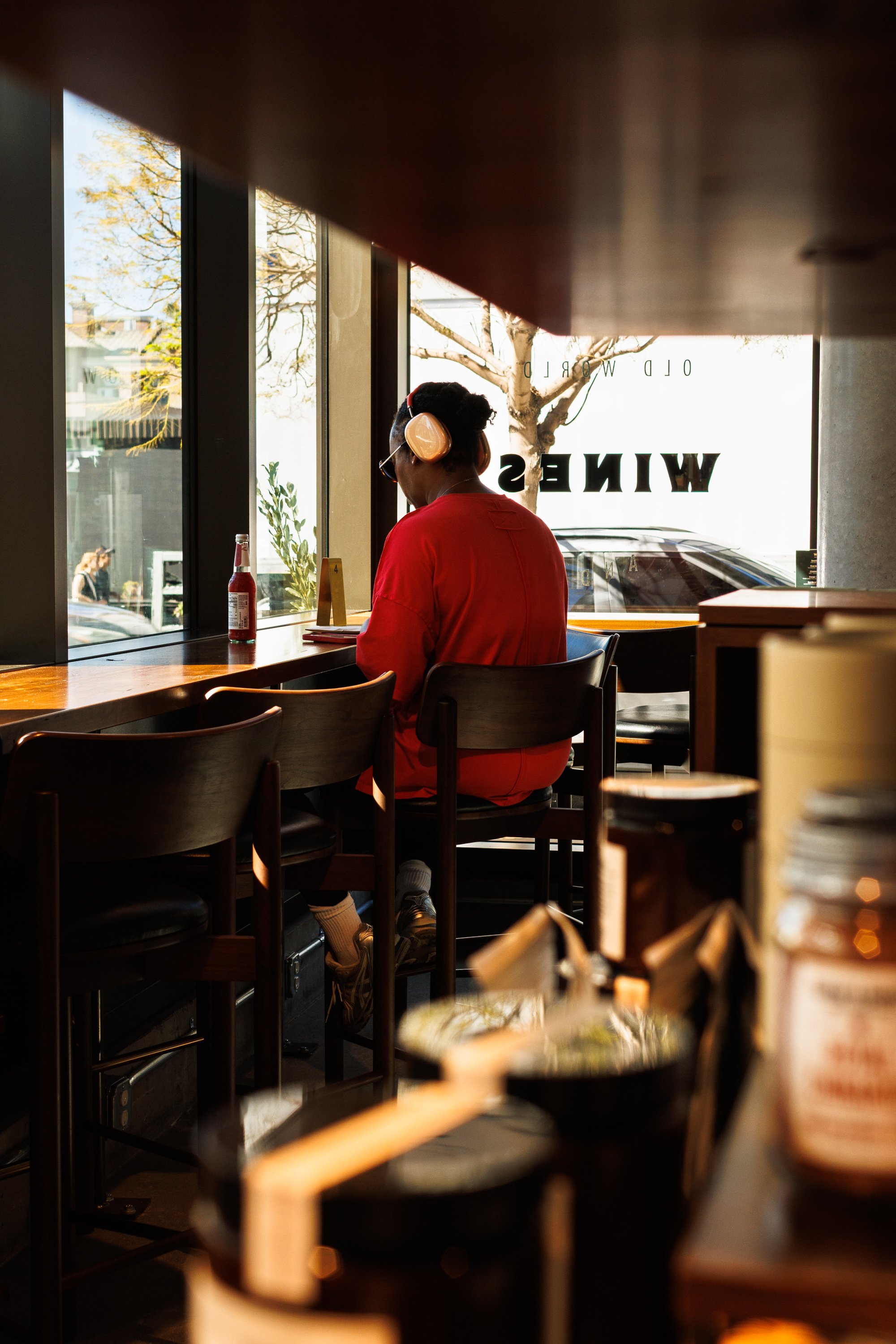 Commercial hospitality lifestyle photo of a woman sitting at a bar in a cafe in San Diego.