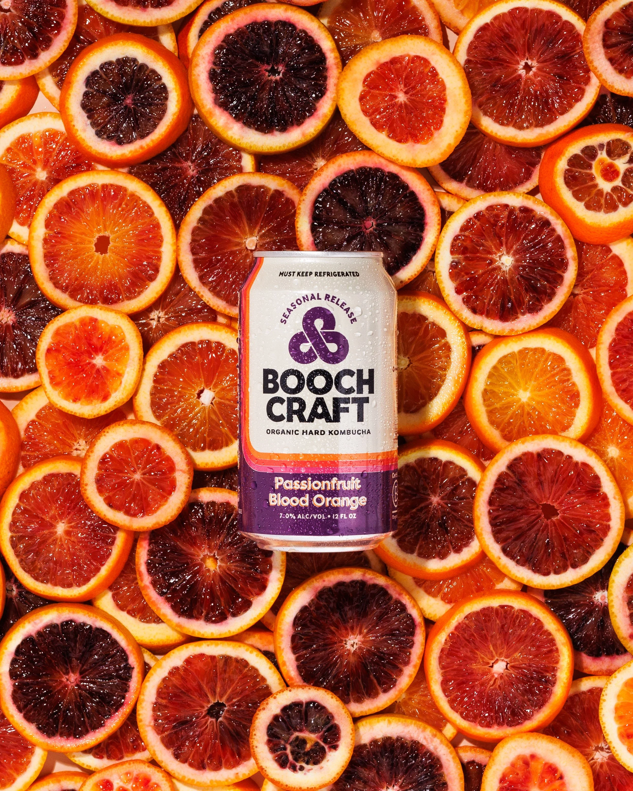 Commercial advertising photo of a canned beverage product on a bed of orange slices.