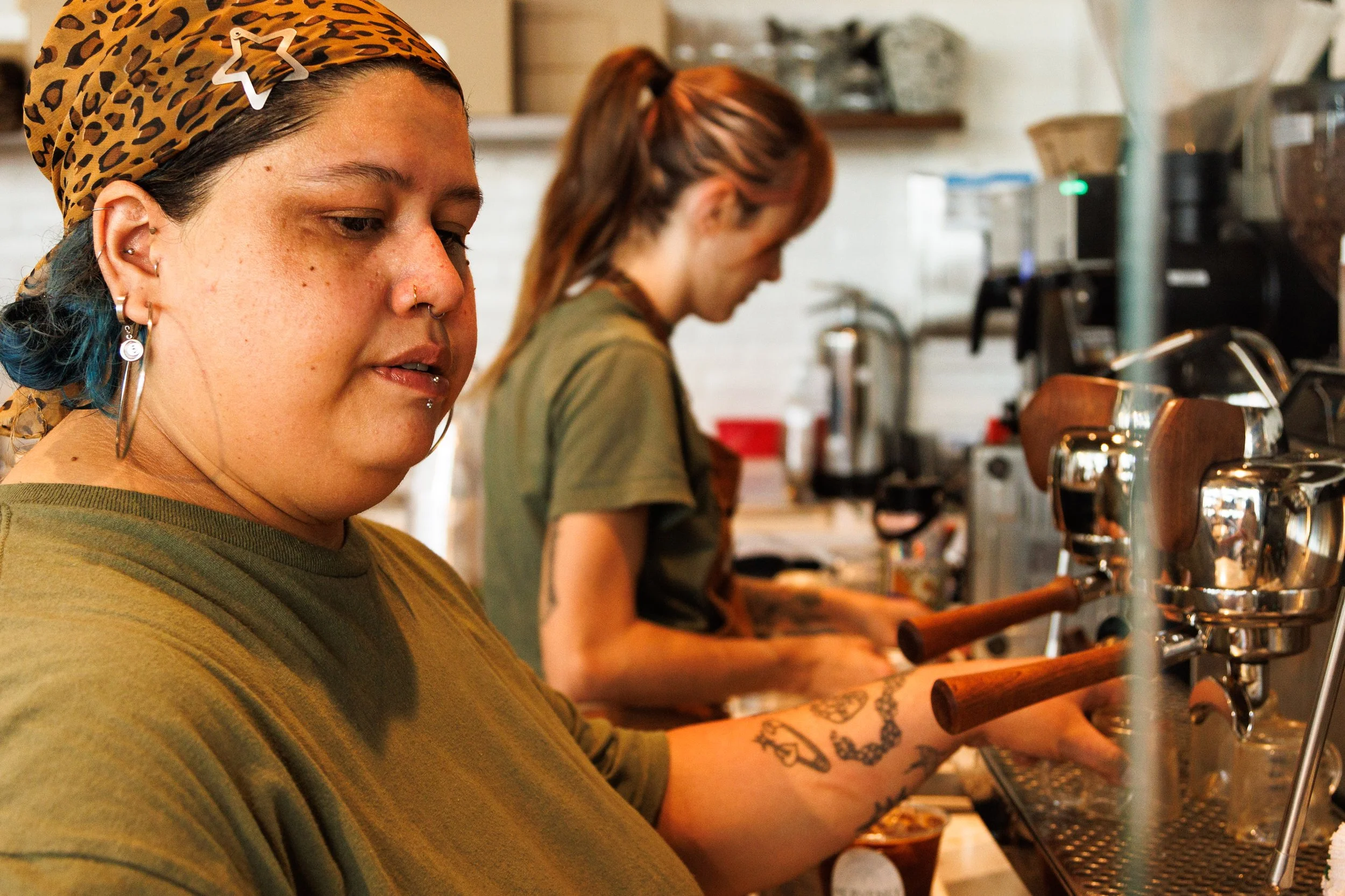 Commercial lifestyle photo of baristas making coffee for a hospitality brand campaign.
