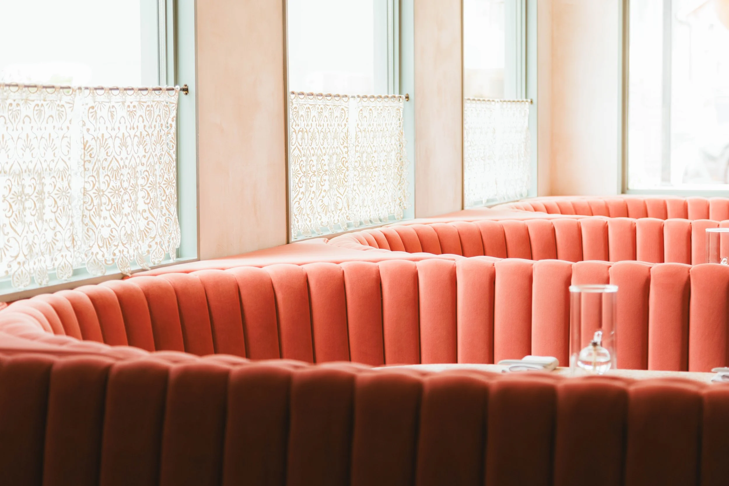 Editorial hospitality photo of the interiors of a restaurant including pink velvet seating.