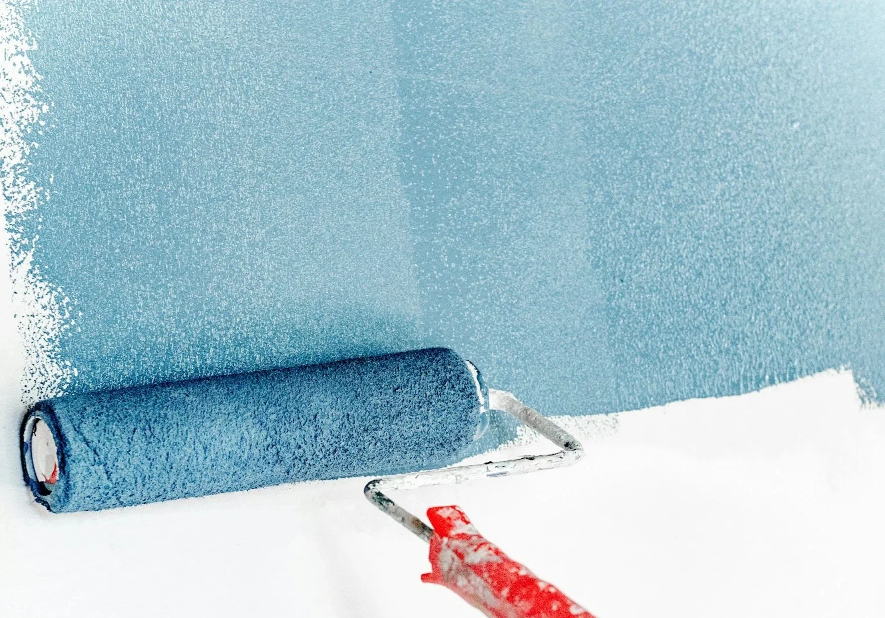 Fresh interior paint being rolled on during a rental unit repaint — painting and drywall service