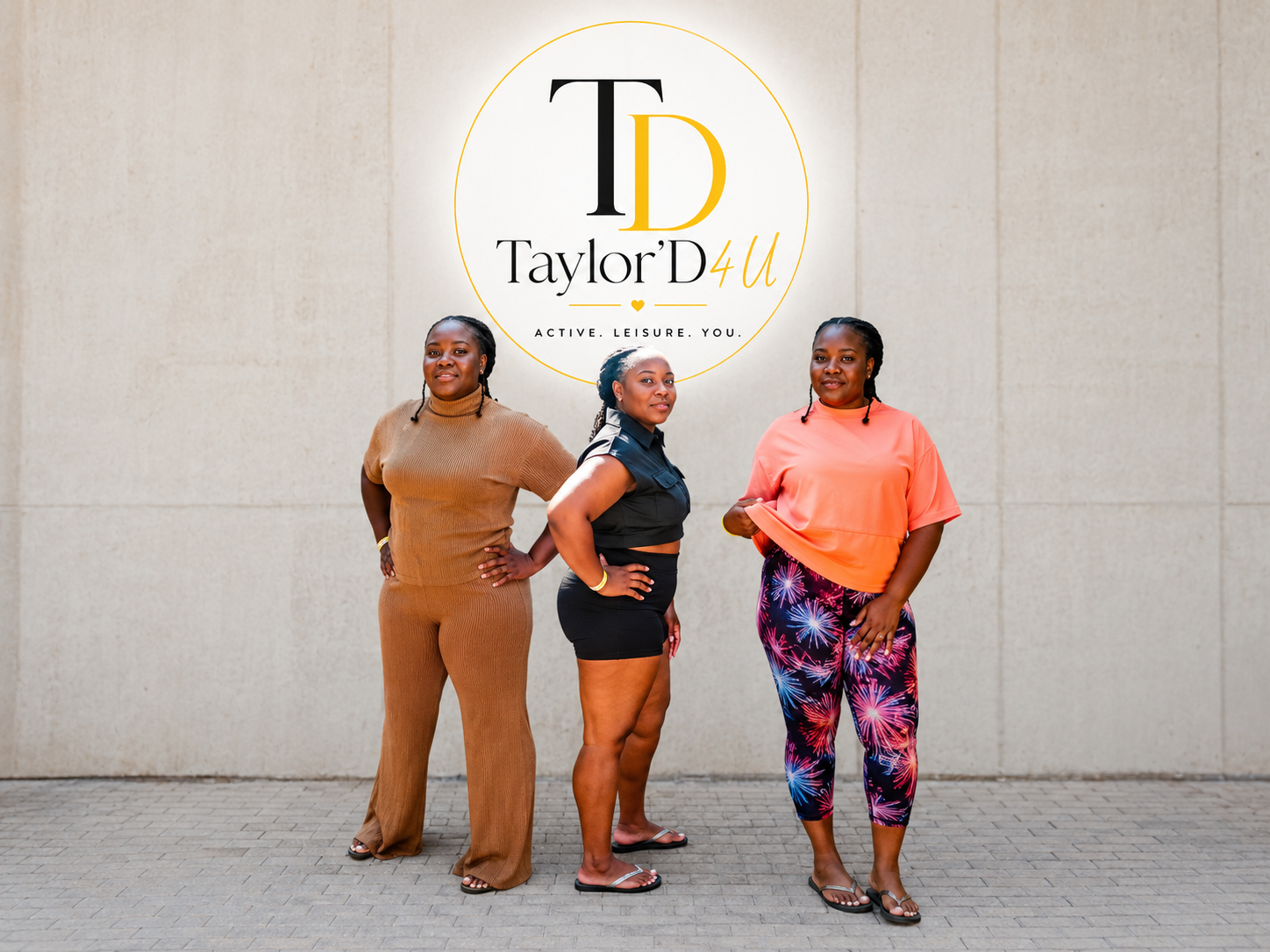 Three women standing in front of a wall with a logo that says 'Taylor'D 4U' and the tagline 'Active. Leisure. You.'