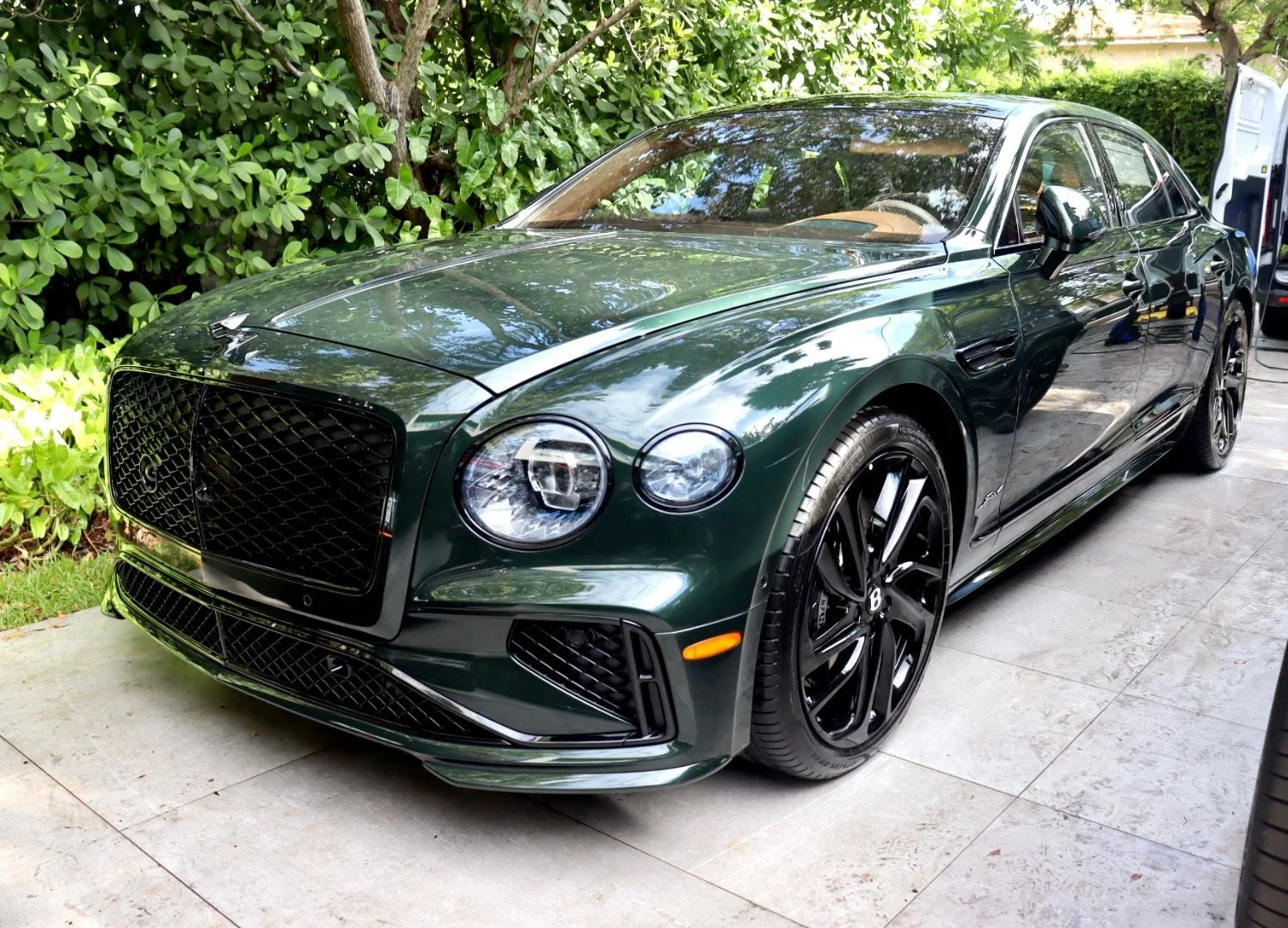 Front three-quarter view of a freshly detailed dark green Bentley.JPG