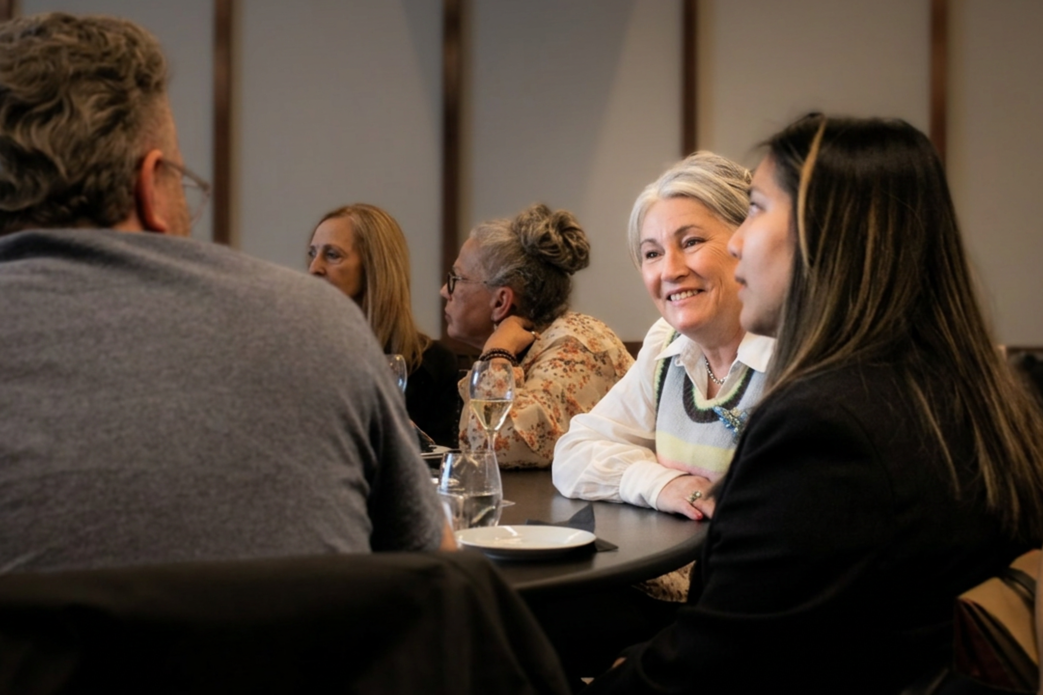 dementia carer guests chat happily at table with wine and canapes