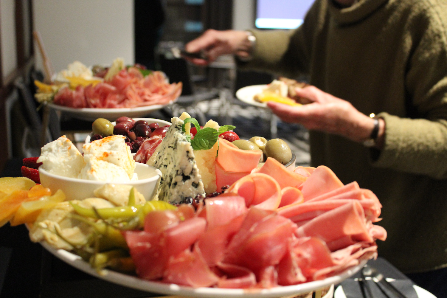 guests enjoying cheese, olives, fruit and cold meats