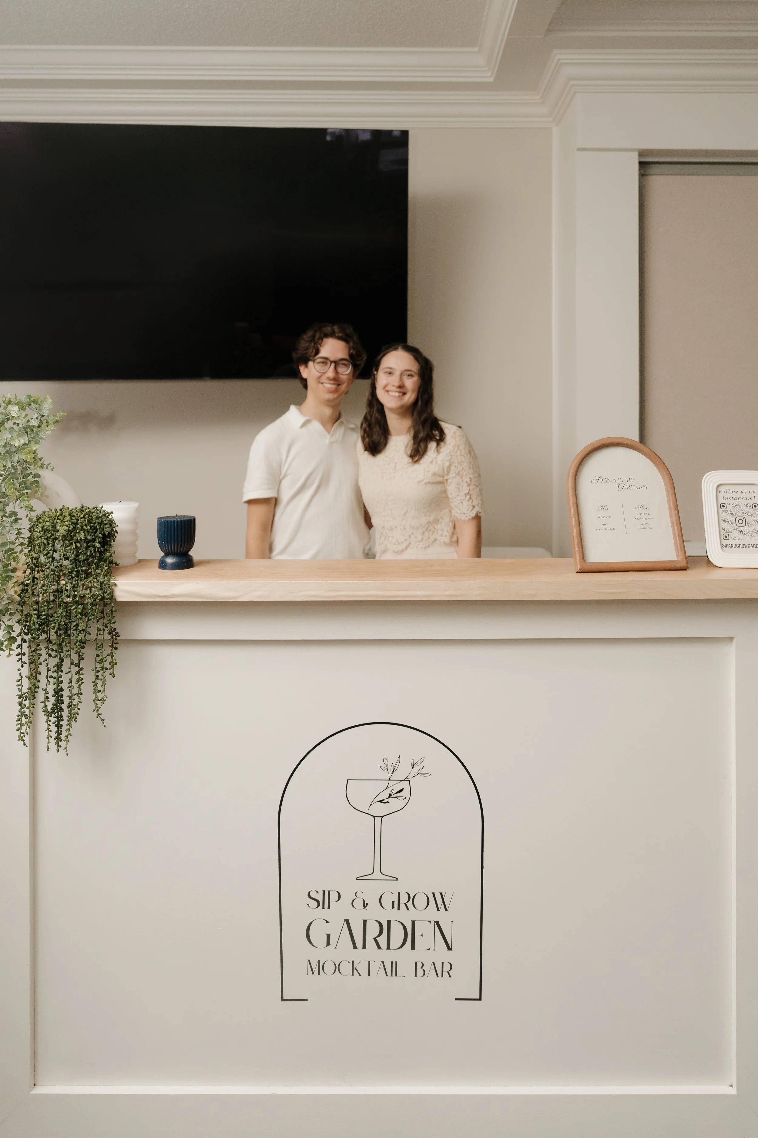 Owners of Sip & Grow Garden standing behind their mobile mocktail bar at a wedding and event setup in Western Massachusetts. Serving alcohol-free, NA, non-alcoholic beverages and mocktails.