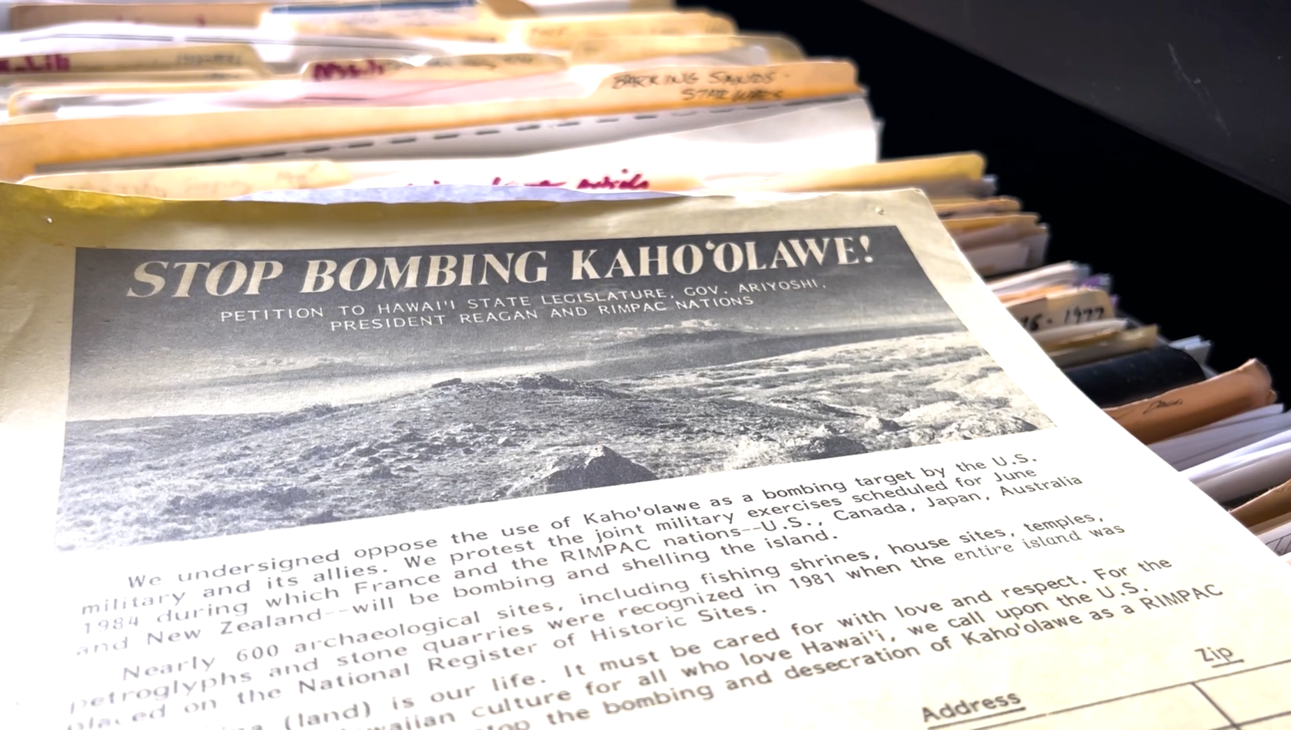 A printed petition titled "Stop Bombing Kahoolawe" with a black and white photo of the island Kahoolawe. The petition text protests United States military bombing exercises on Kahoolawe.
