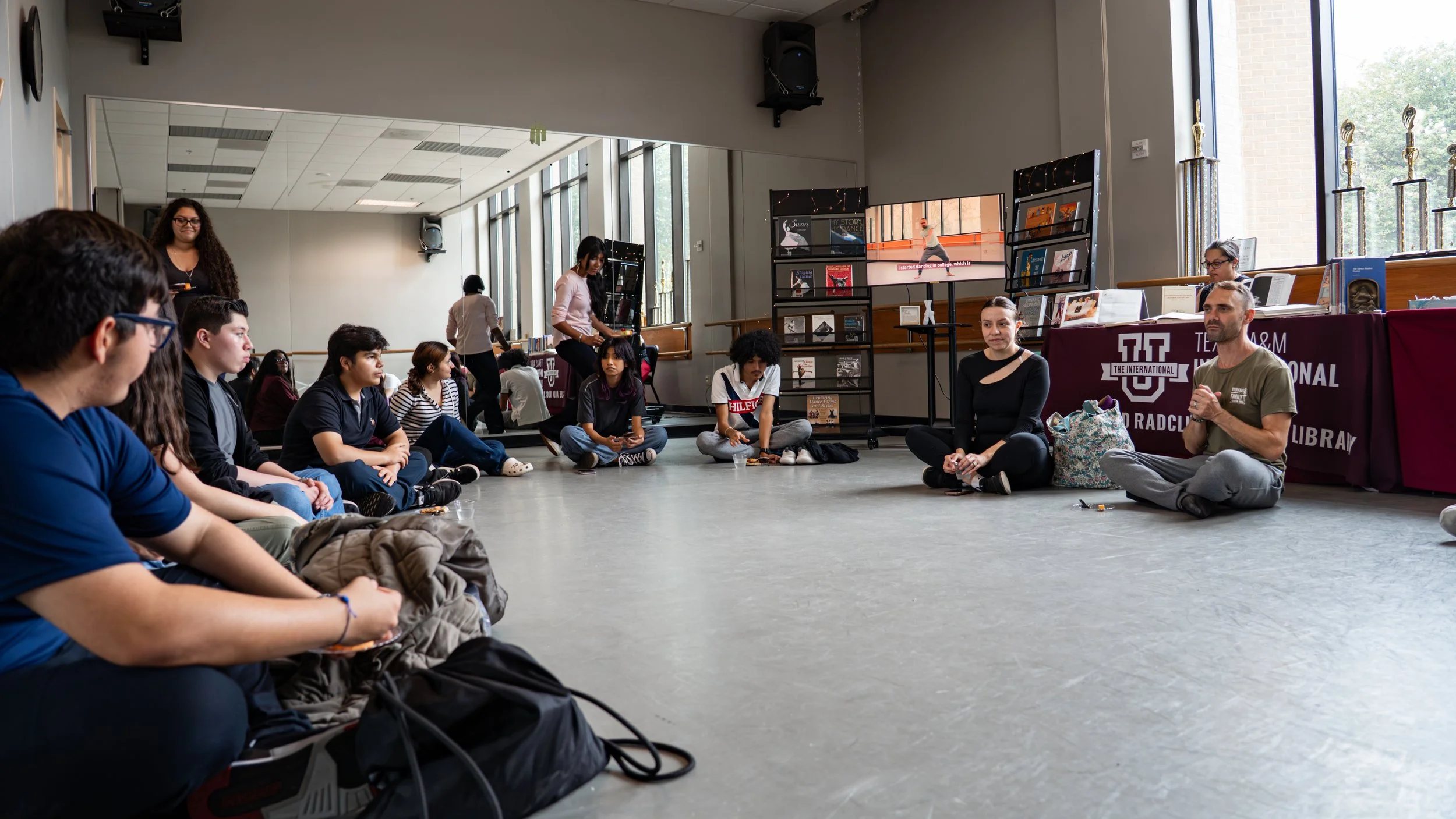 A majority of the participants sitting in the dance studio and experiencing the living library part of the event.