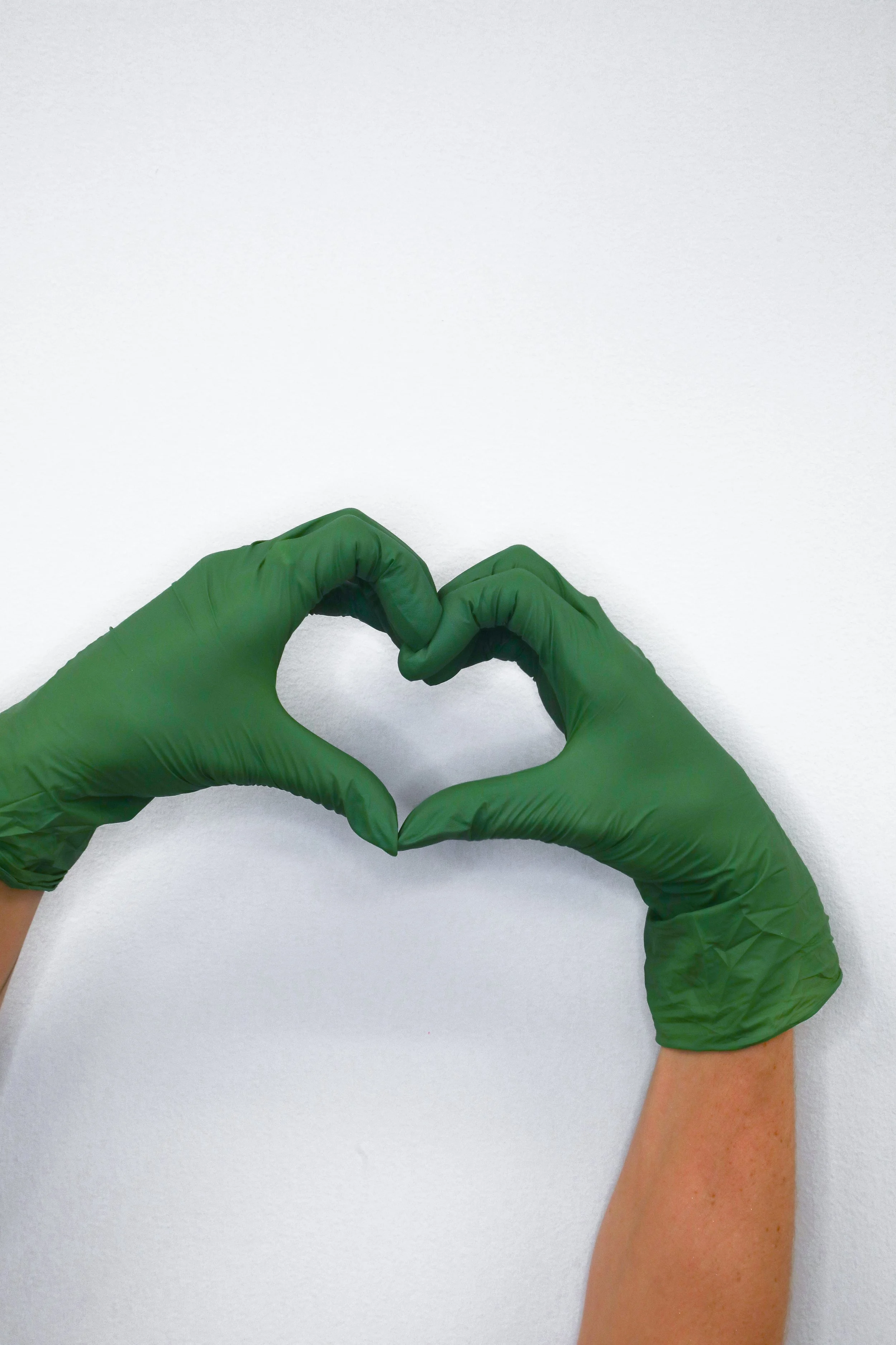 making a heart with green latex free gloves on