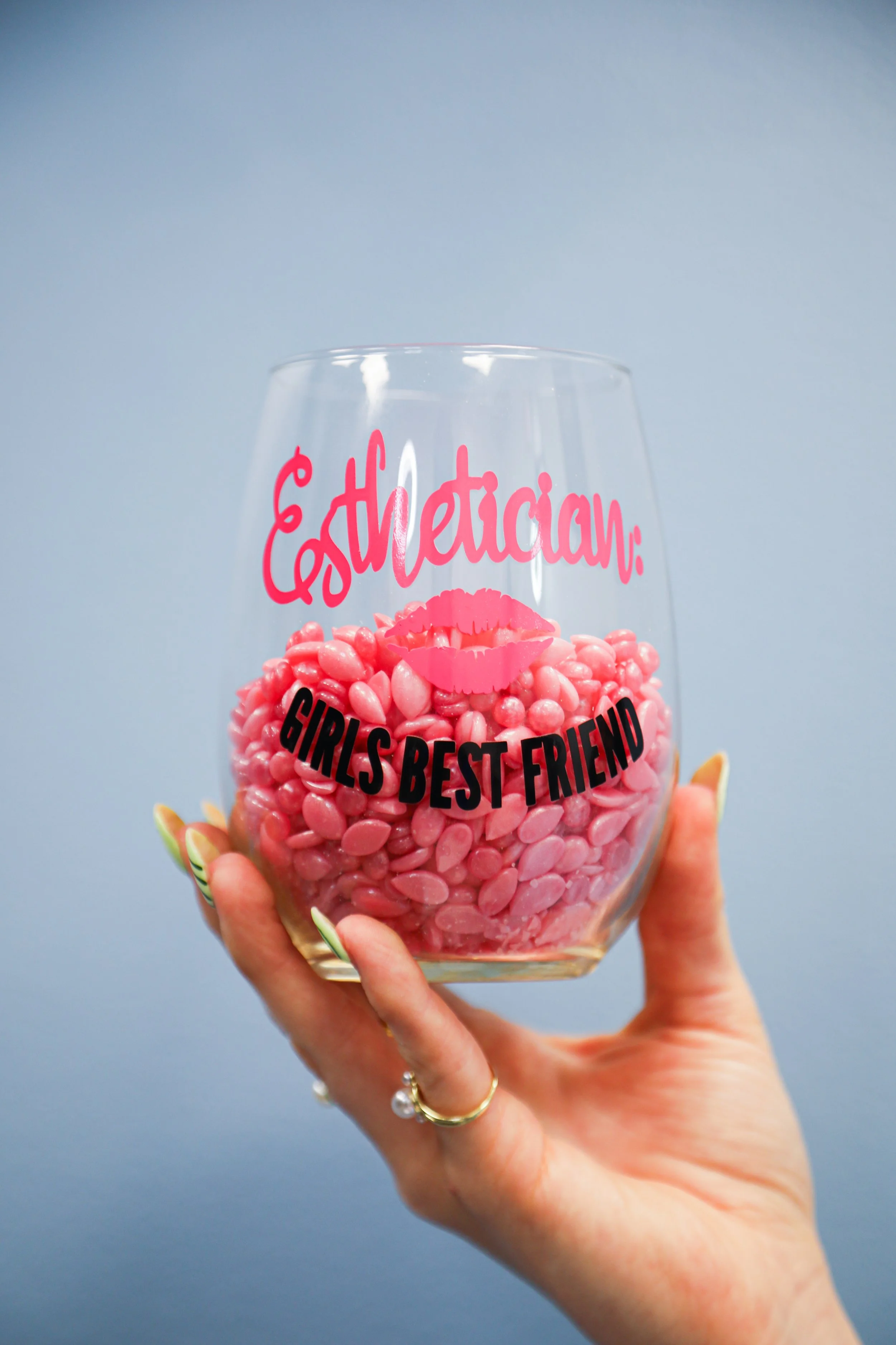 esthetician is a girls best friend wine glass full of pink wax beads