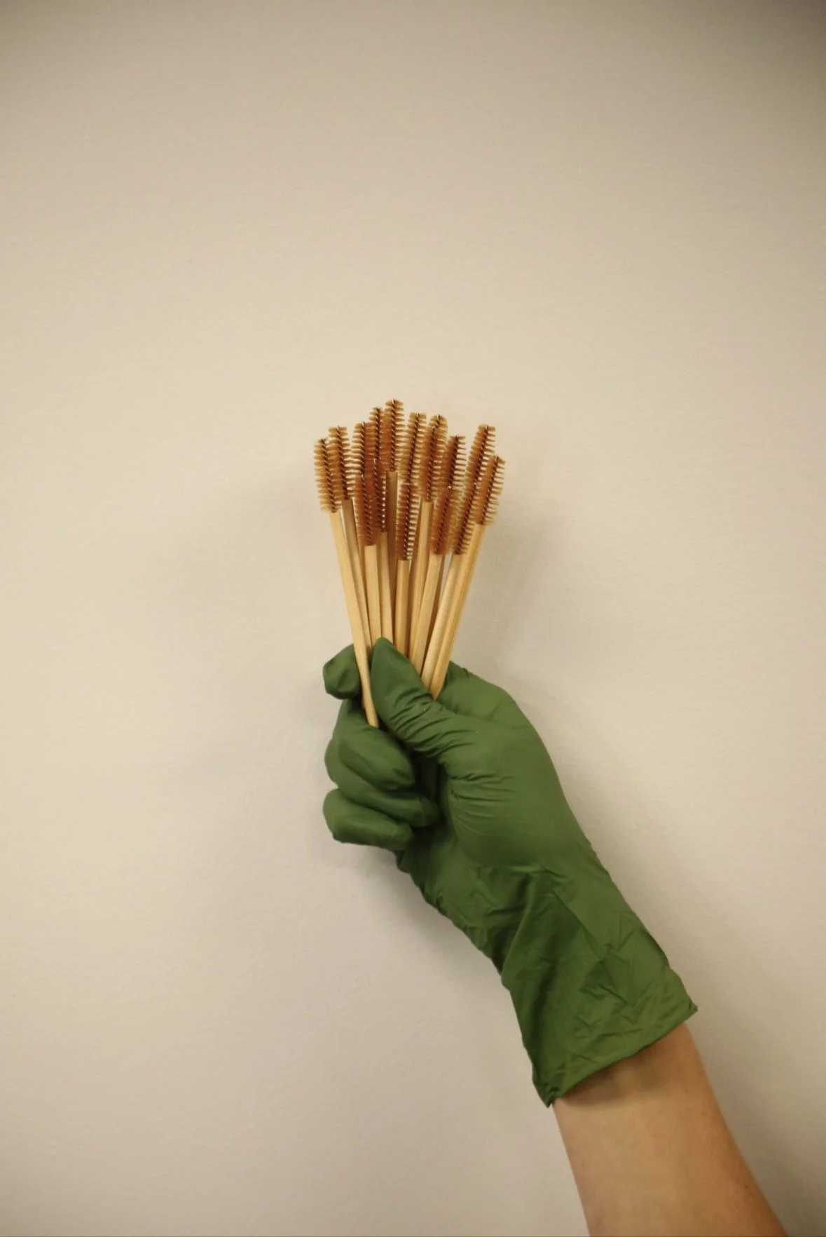 holding eyebrow, eyelash brushes in hand spread out