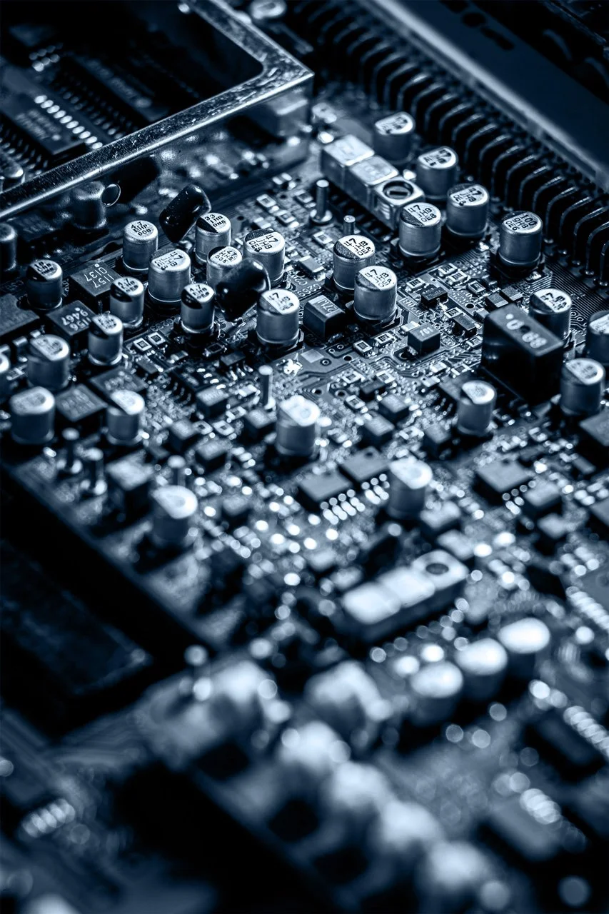Close-up of a computer motherboard with various capacitors and electronic components, Searchlight New Zealand's leading network experts