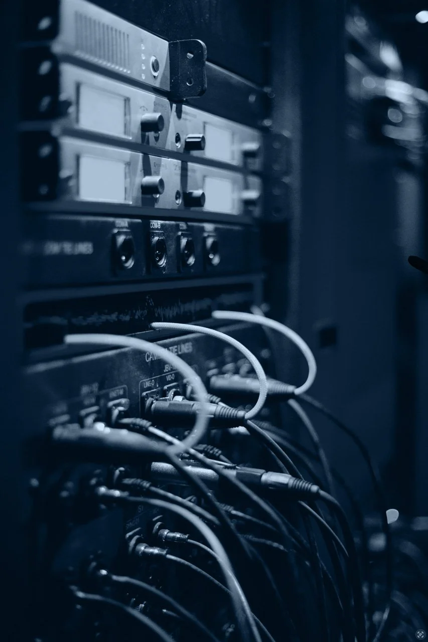Server rack with multiple cables connected, shot in a dark environment with blue lighting, mission critical infrastructure, network modernisation Auckland