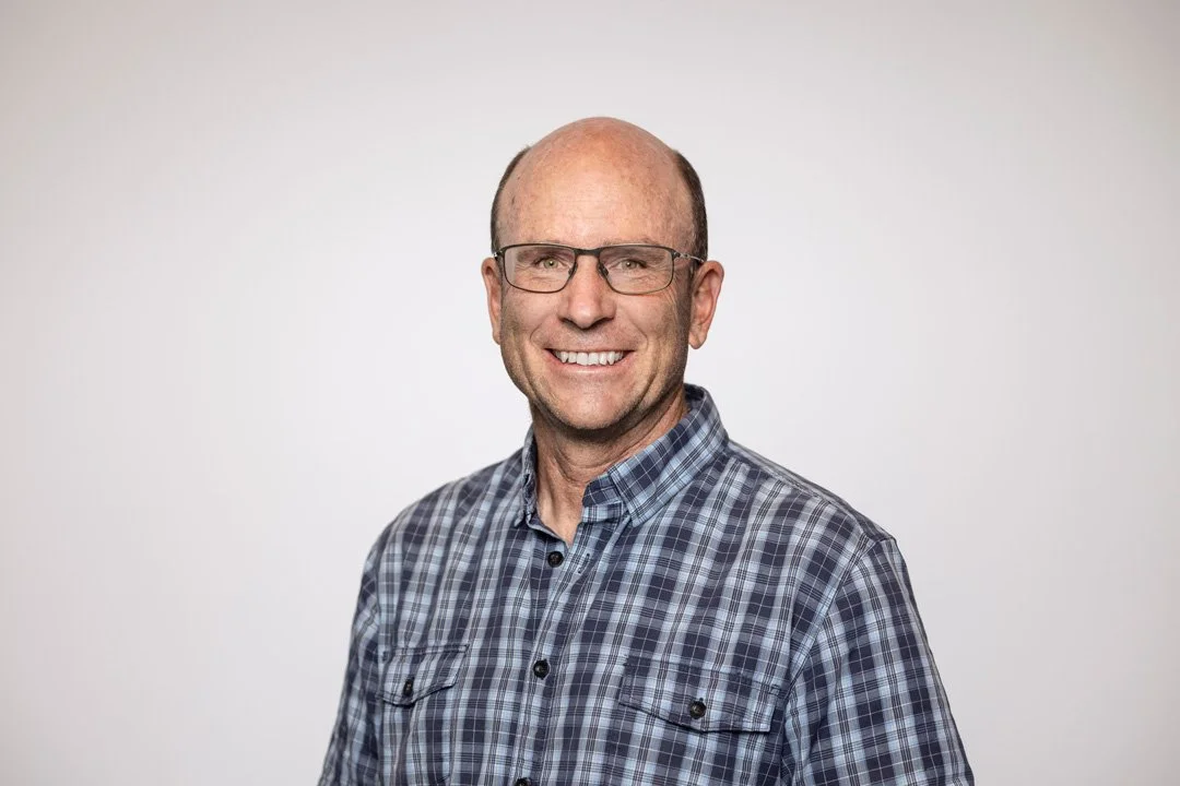 Richard, OpenLI Consultant at Searchlight - Infrastructure lifecycle management Auckland New Zealand, smiling man with glasses, wearing a plaid shirt, posed against a plain white background.