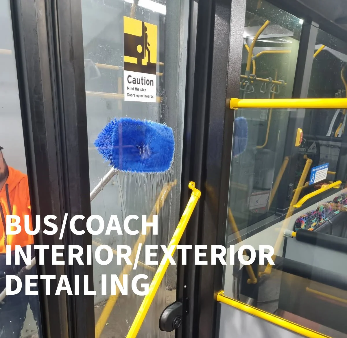 Inside and exterior detailing of a bus or coach. A person is cleaning the exterior glass door with a blue cleaning tool. Yellow handrails are visible inside the bus, and there's a caution sign on the door warning about inward opening doors.