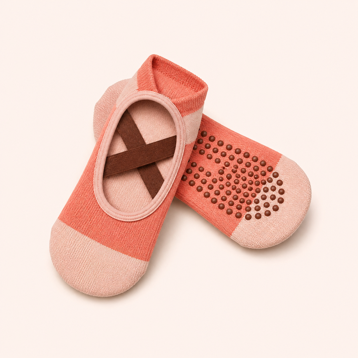 A pair of pink and coral therapeutic slippers with textured soles and open toes resting on a white background.