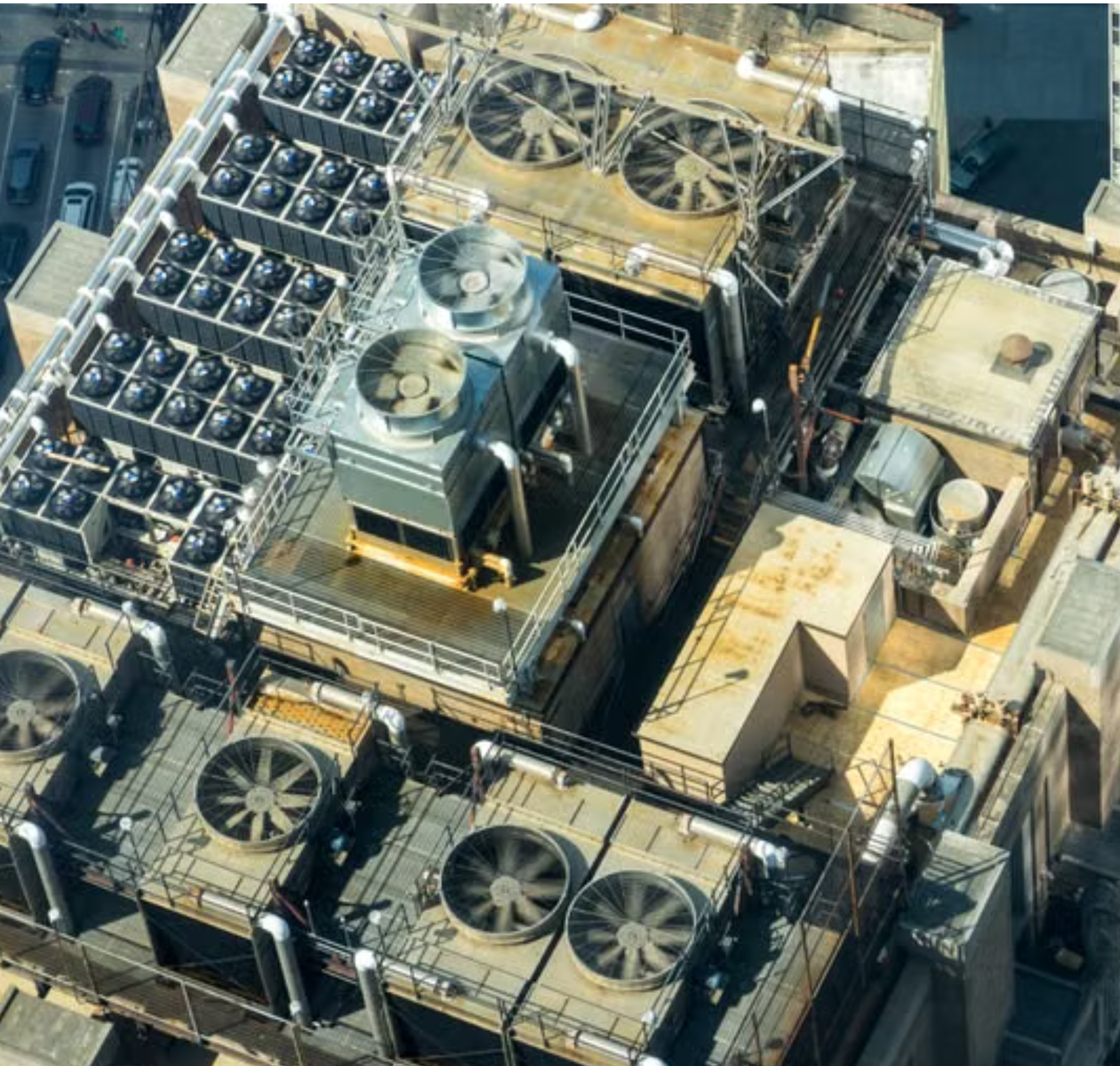 An aerial view of a building under construction with steel framework, large industrial fans, and multiple floors.