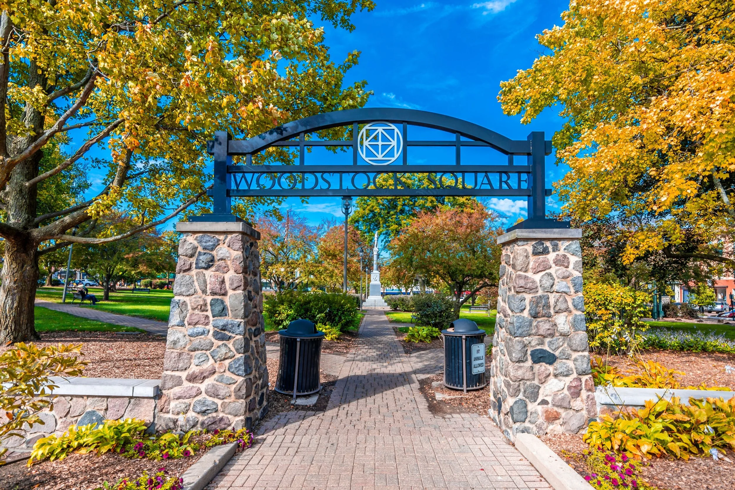 The entrance to Woodstock Square surrounded by colorful trees and landscaping.