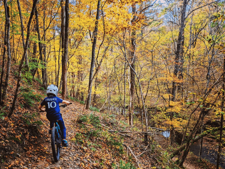 Mountain biker riding through the wooded trails at Olde Rope Mill Park