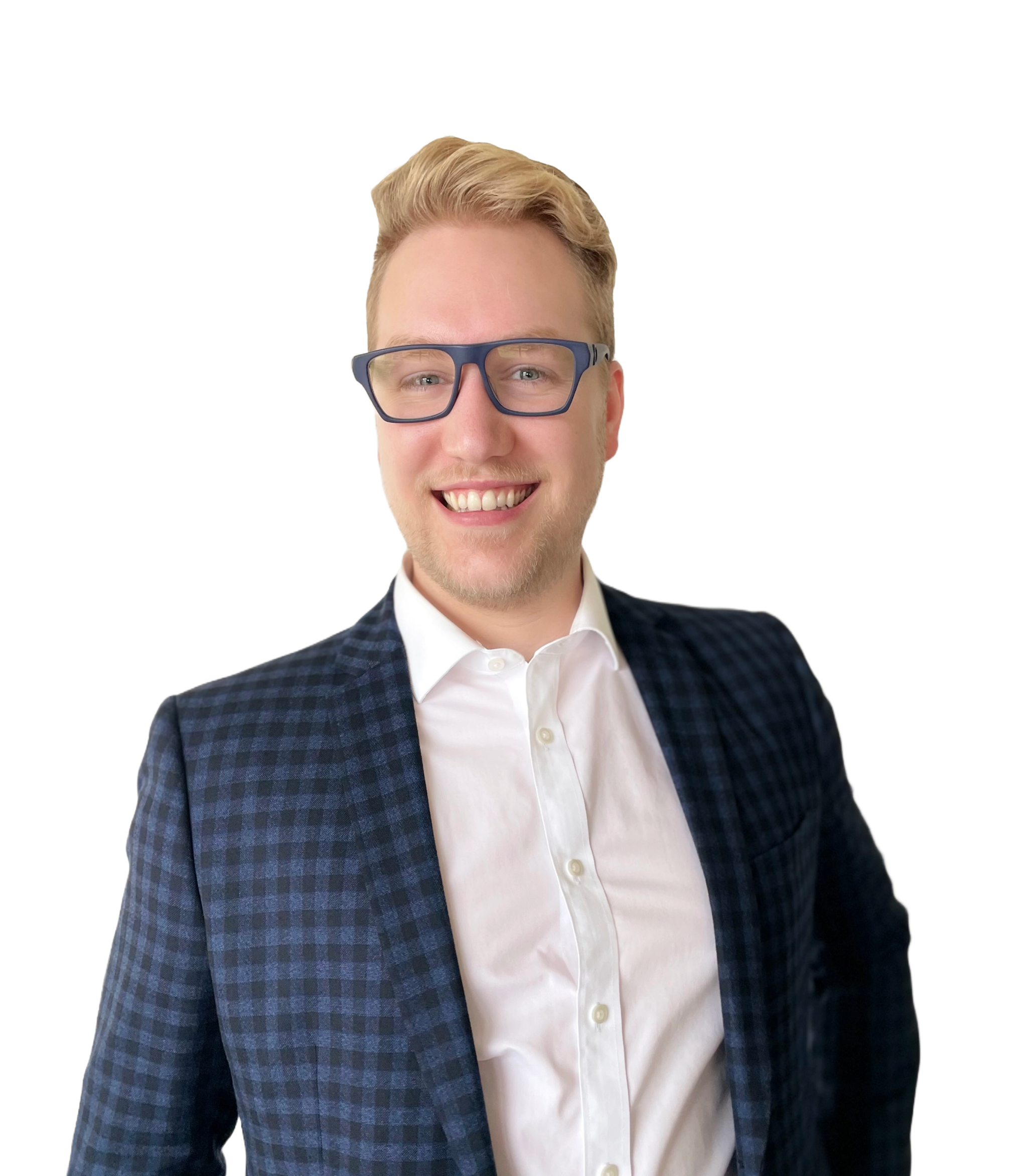Close-up of a young man with blonde hair, smiling, wearing glasses, a white shirt, and a dark checkered blazer, against a background with colorful horizontal lines.