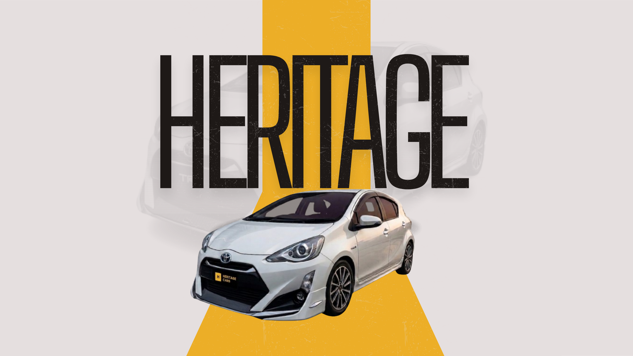 A white Toyota hatchback car in front of the word 'Heritage' written in black capital letters over a yellow background. The car has a Heritage Cars license plate.