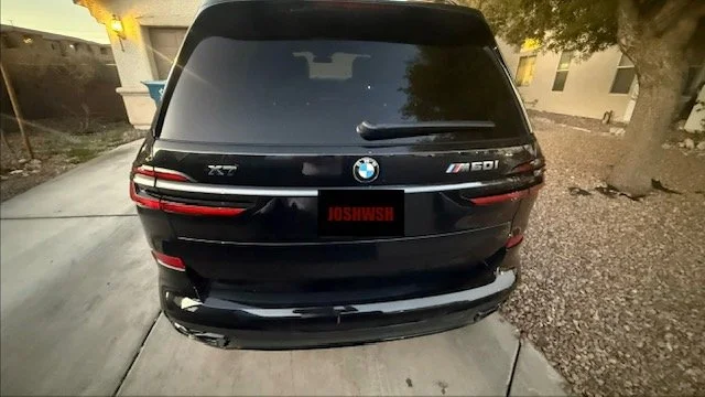 Black BMW X7 SUV parked on a driveway with a tree and house in the background. Josh's Washes Las Vegas's best mobile detailing company. Ceramic coating