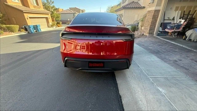 Red electric vehicle parked in driveway with a house and garage in the background. Mobile car wash. Mobile car detailer Las Vegas. Tesla