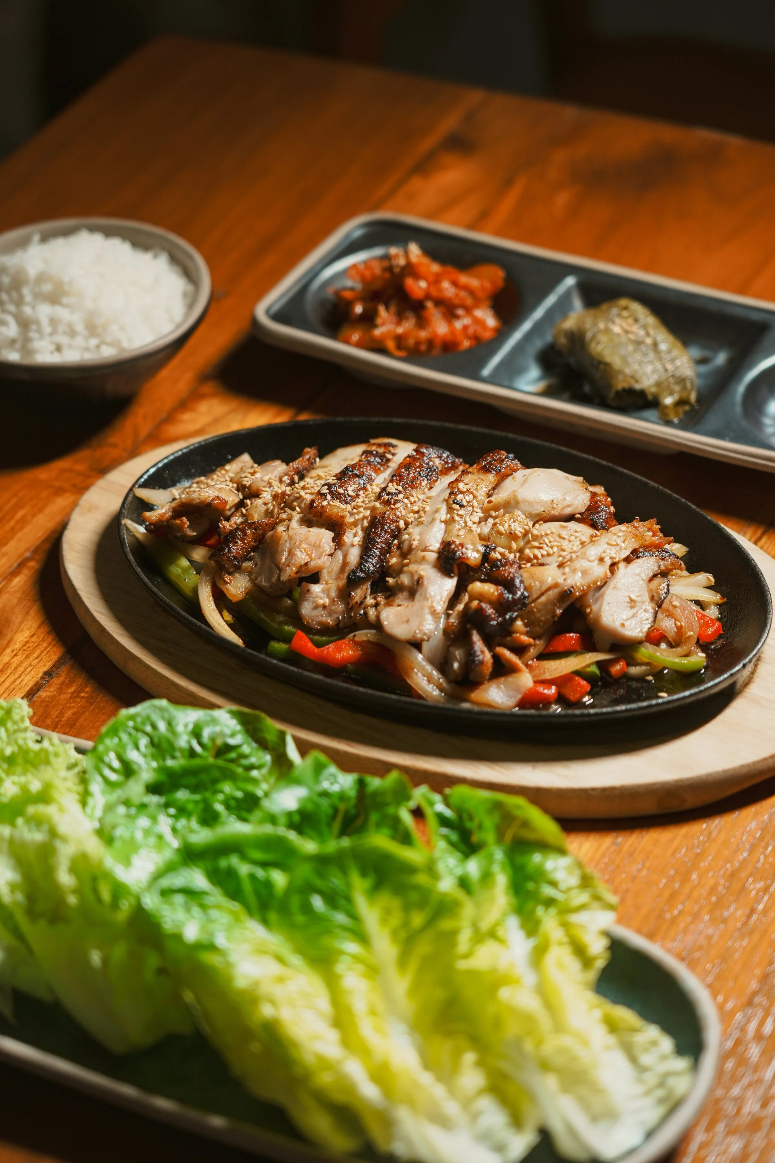 Grilled chicken BBQ served as part of the Korean Set at Vatos, with ssam, kimchi, and rice