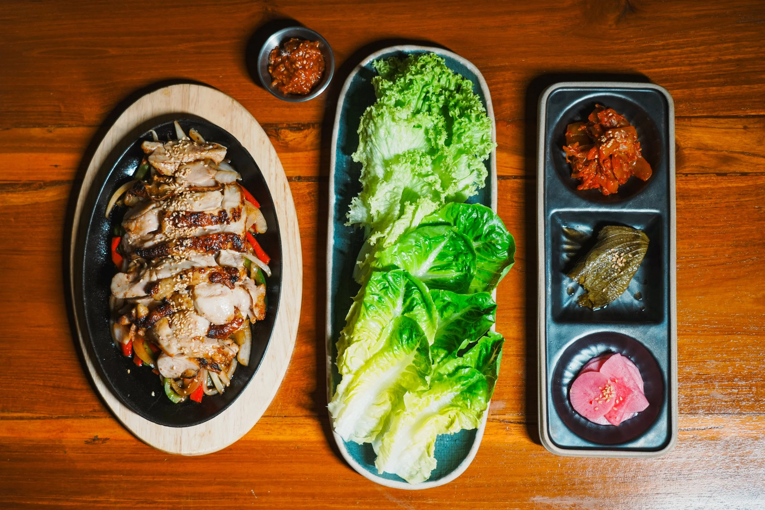 Grilled chicken BBQ served as part of the Korean Set at Vatos, with ssam, kimchi, and rice