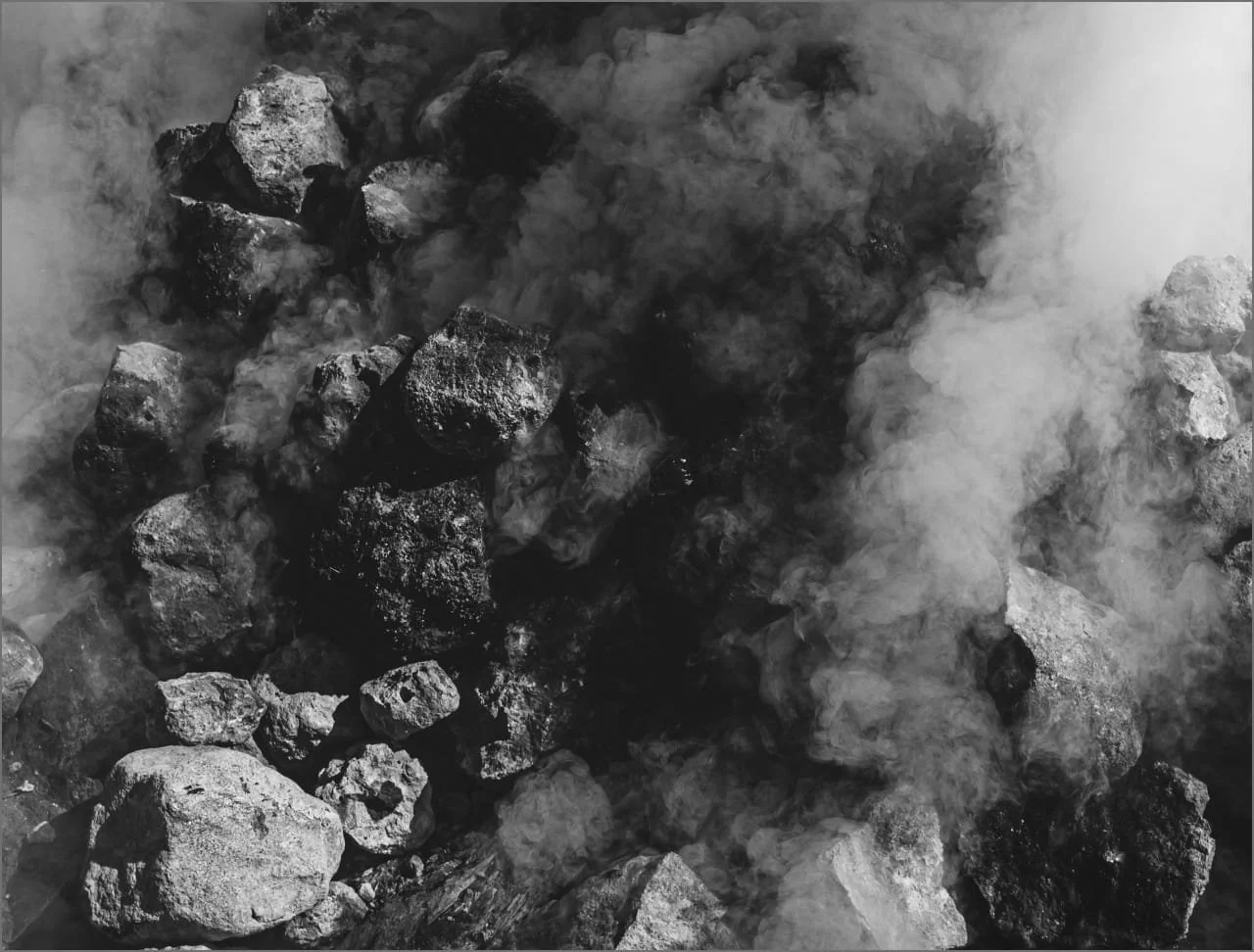 Hot rocks emitting steam or smoke, used for the process of grinding agave plant hearts to make top rated mezcal.