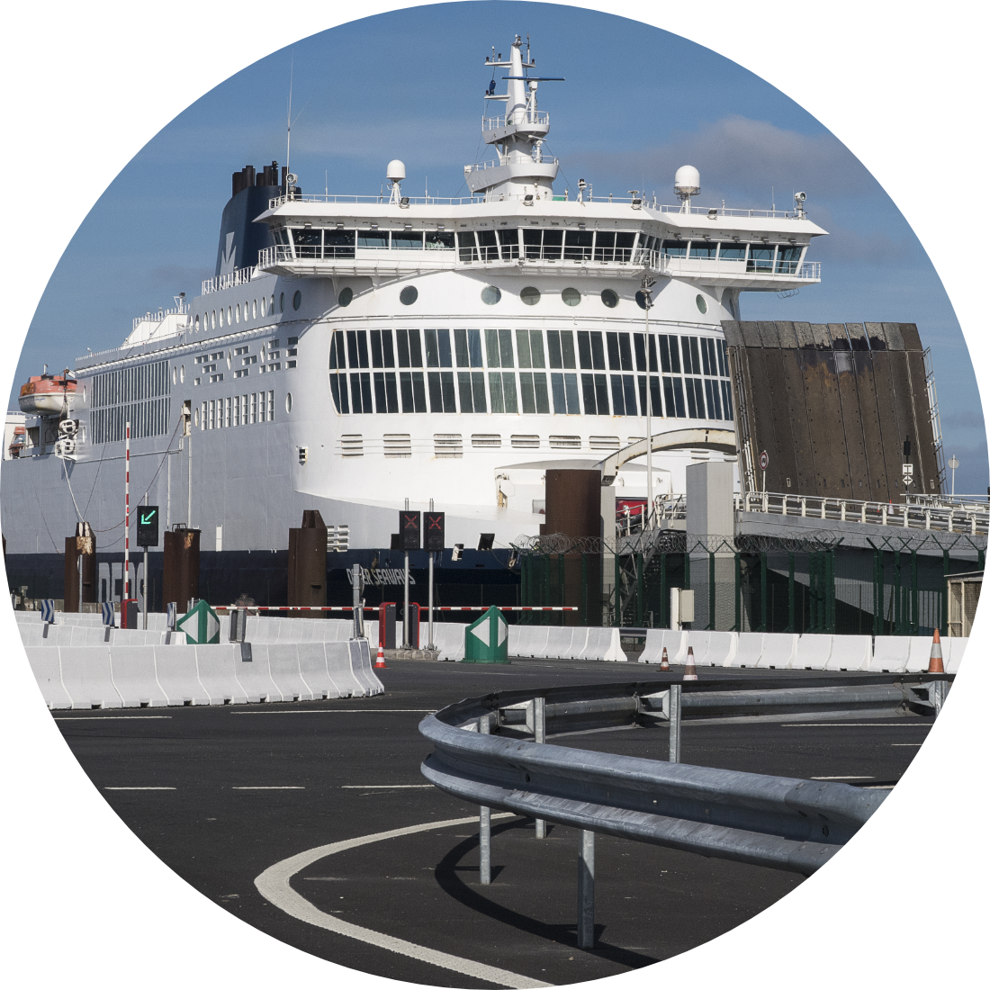Large white passenger ferry docked at a seaport in Dover with the arrival road in the foreground.