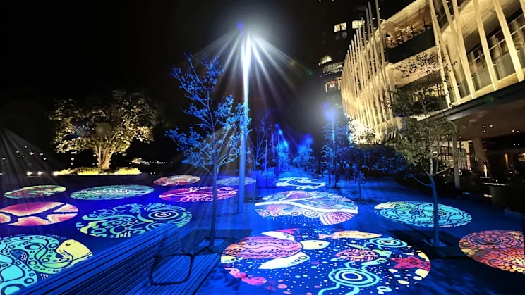 Coda Ridley's art exhibited as light projections on the ground at the Wulugul Walk at Barangaroo at Vivid Sydney.