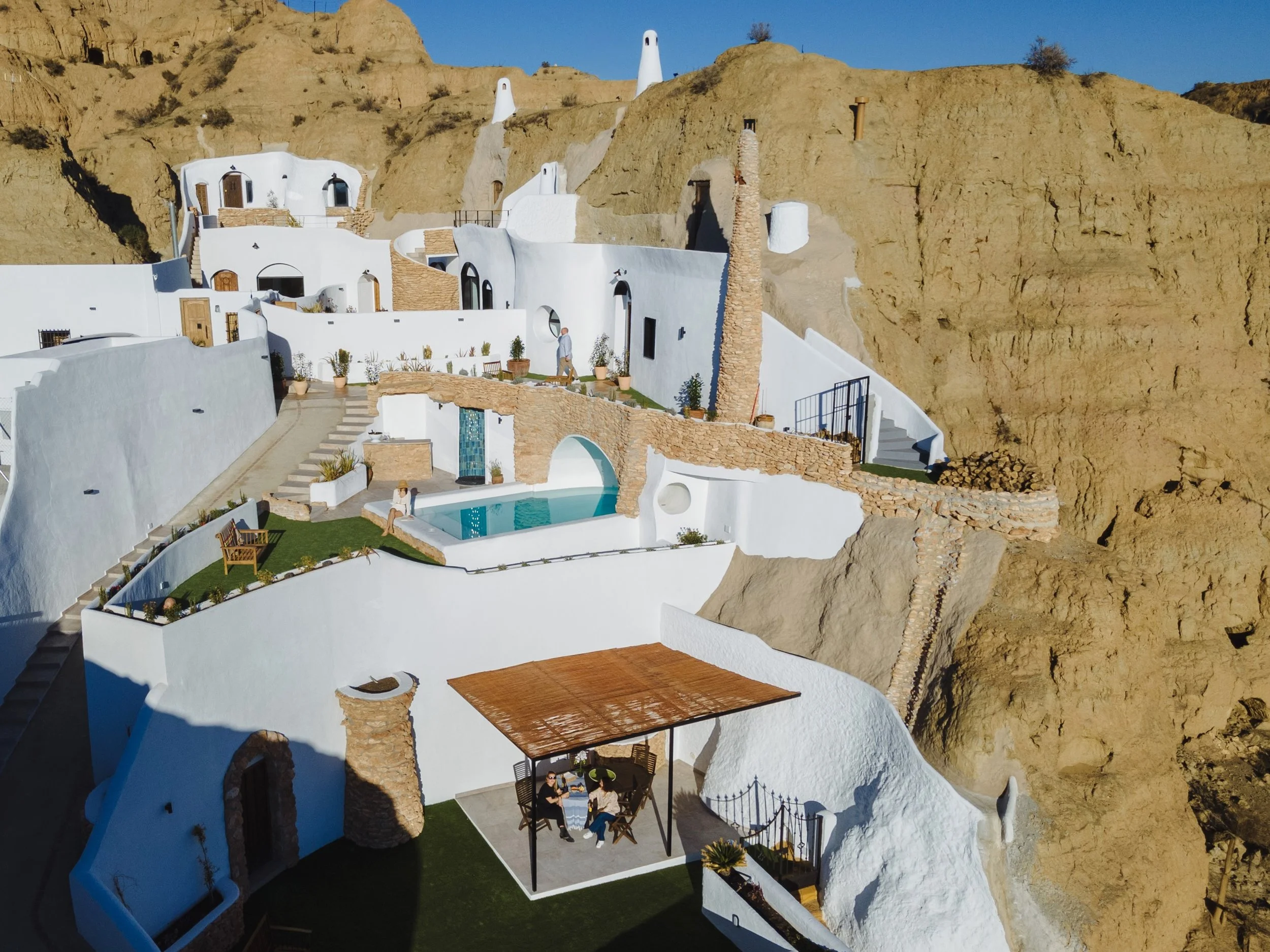 Vista exterior de Cuevas de Kabila, alojamientos cueva excavados en la montaña con piscina y terrazas privadas en Benalúa de Guadix.