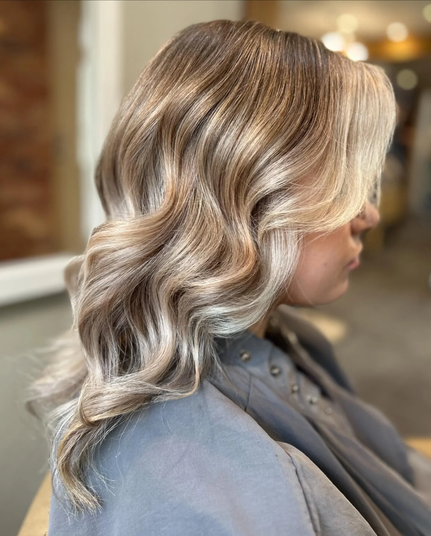 Side view of a woman with long, wavy, blonde hair.