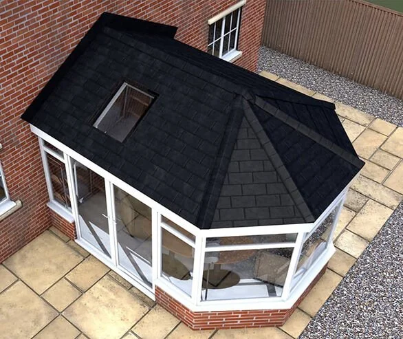 A small attached sunroom or porch with large glass windows, a black shingled gable roof with a small window, and brick walls, connected to a brick house with a patio area and a gravel section enclosed by a wooden fence.