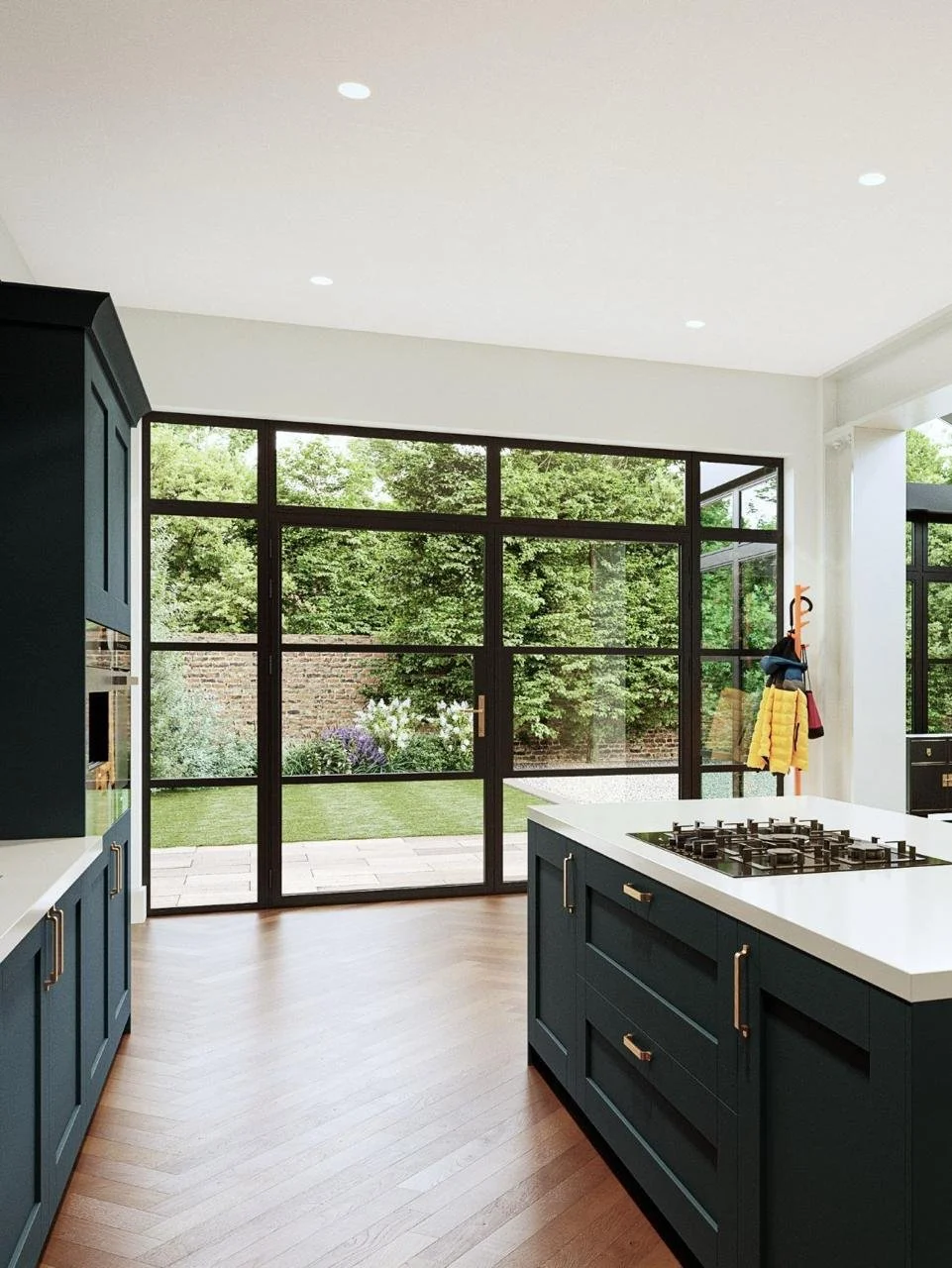 Modern kitchen with navy blue cabinets, white quartz countertops, and large black-framed glass doors opening to a backyard garden with grass, plants, and trees.
