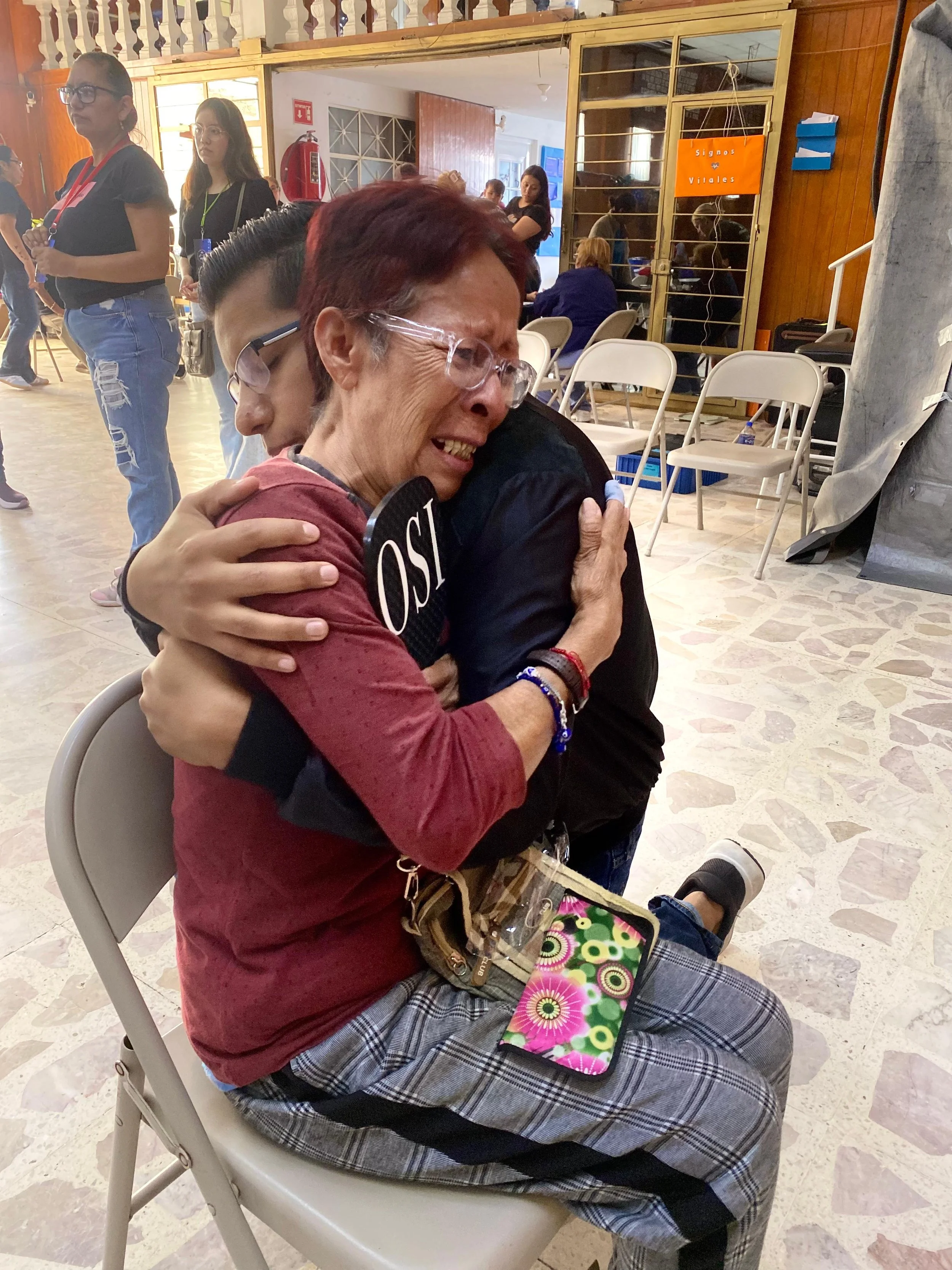 Woman in tears receives a comforting hug and encouragement from an Operation Serve team member