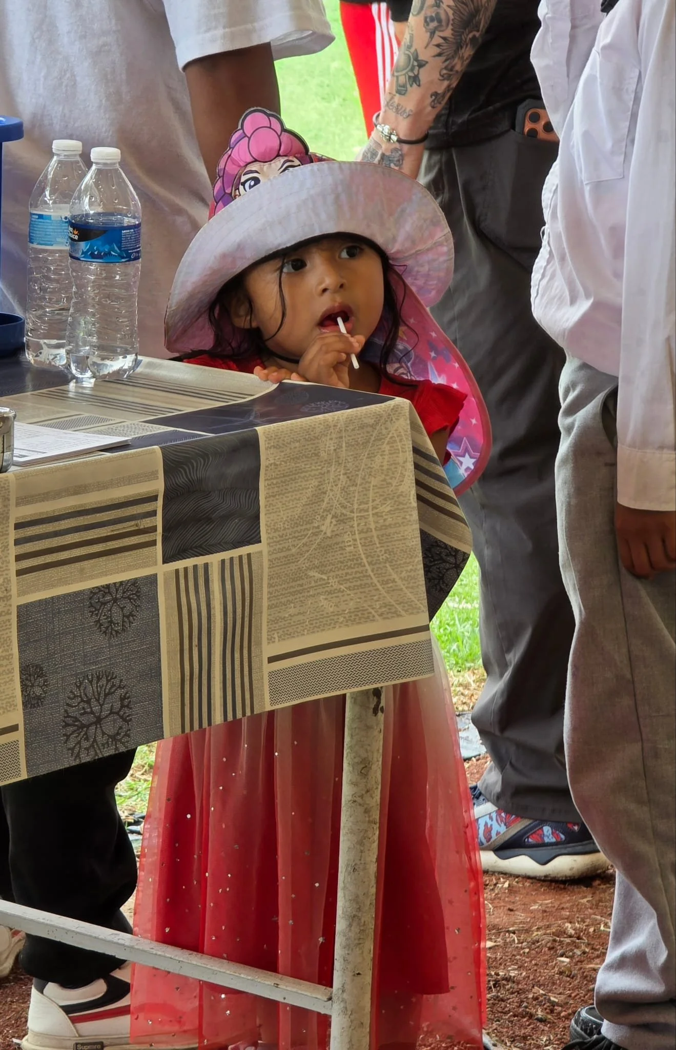 Young girl enjoying a lollipop while attending an Operation Serve International community outreach.