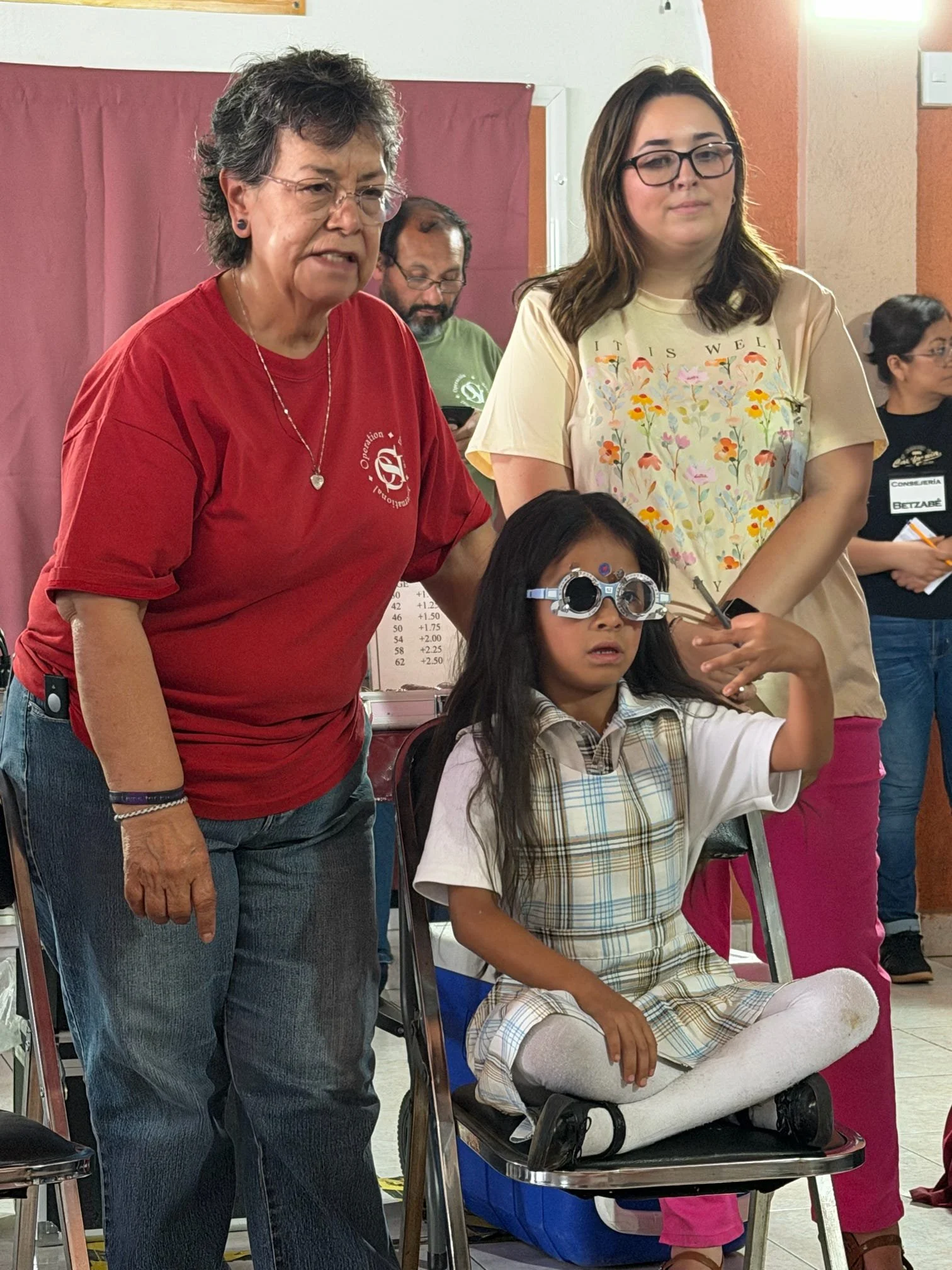 Young girl participating in a vision screening during an Operation Serve International medical clinic.