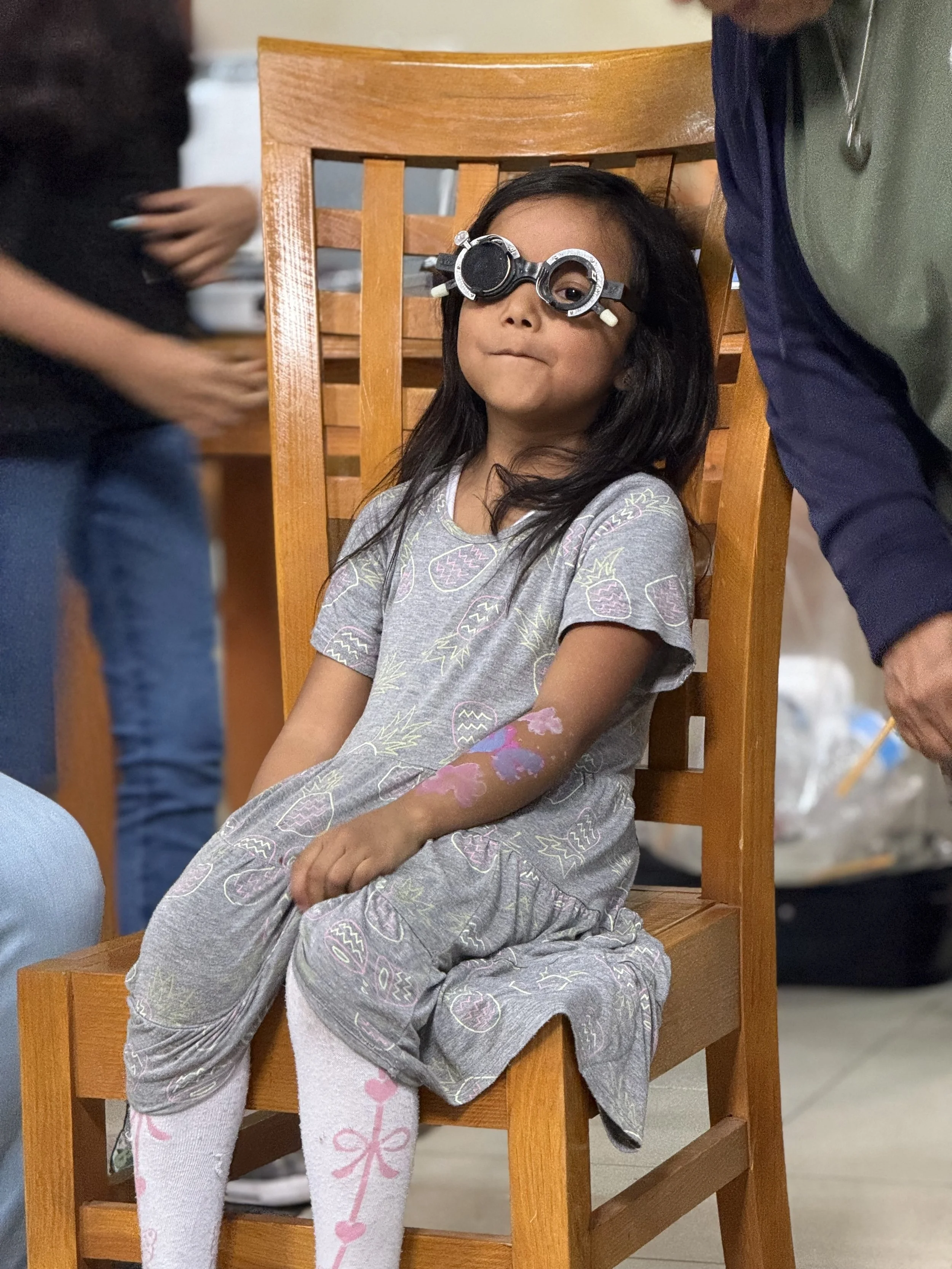Young girl participating in a vision screening during an Operation Serve International medical clinic.