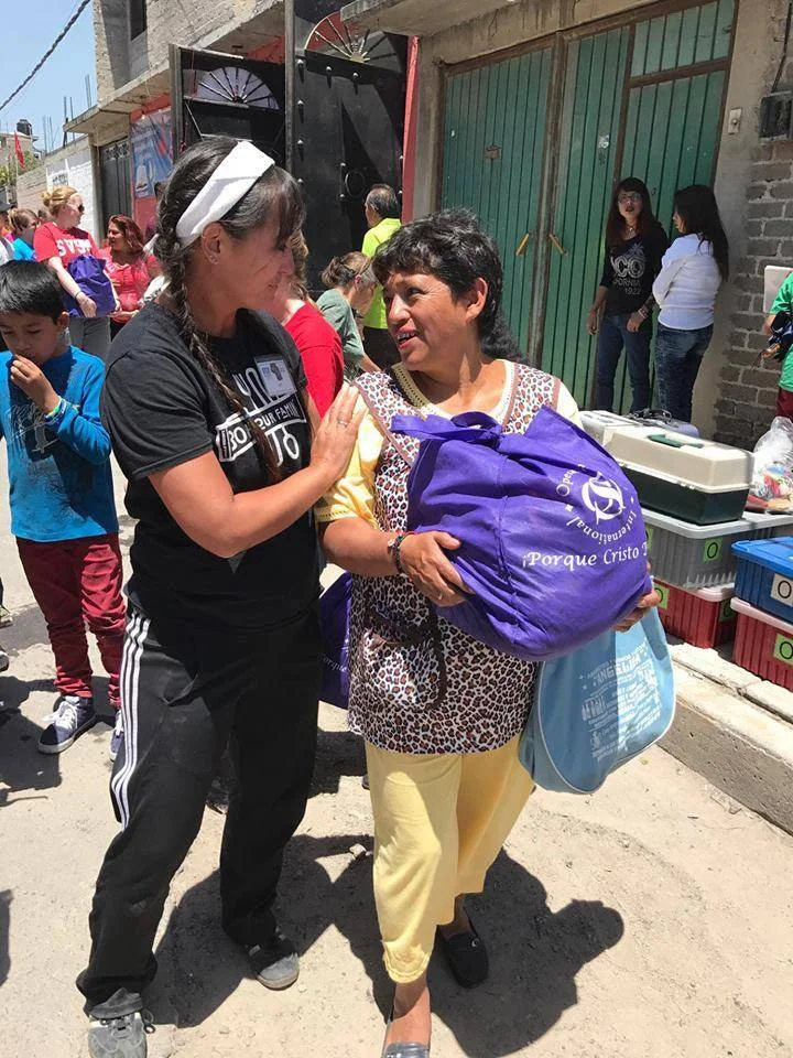 Volunteer walking alongside a community member after receiving donated supplies.