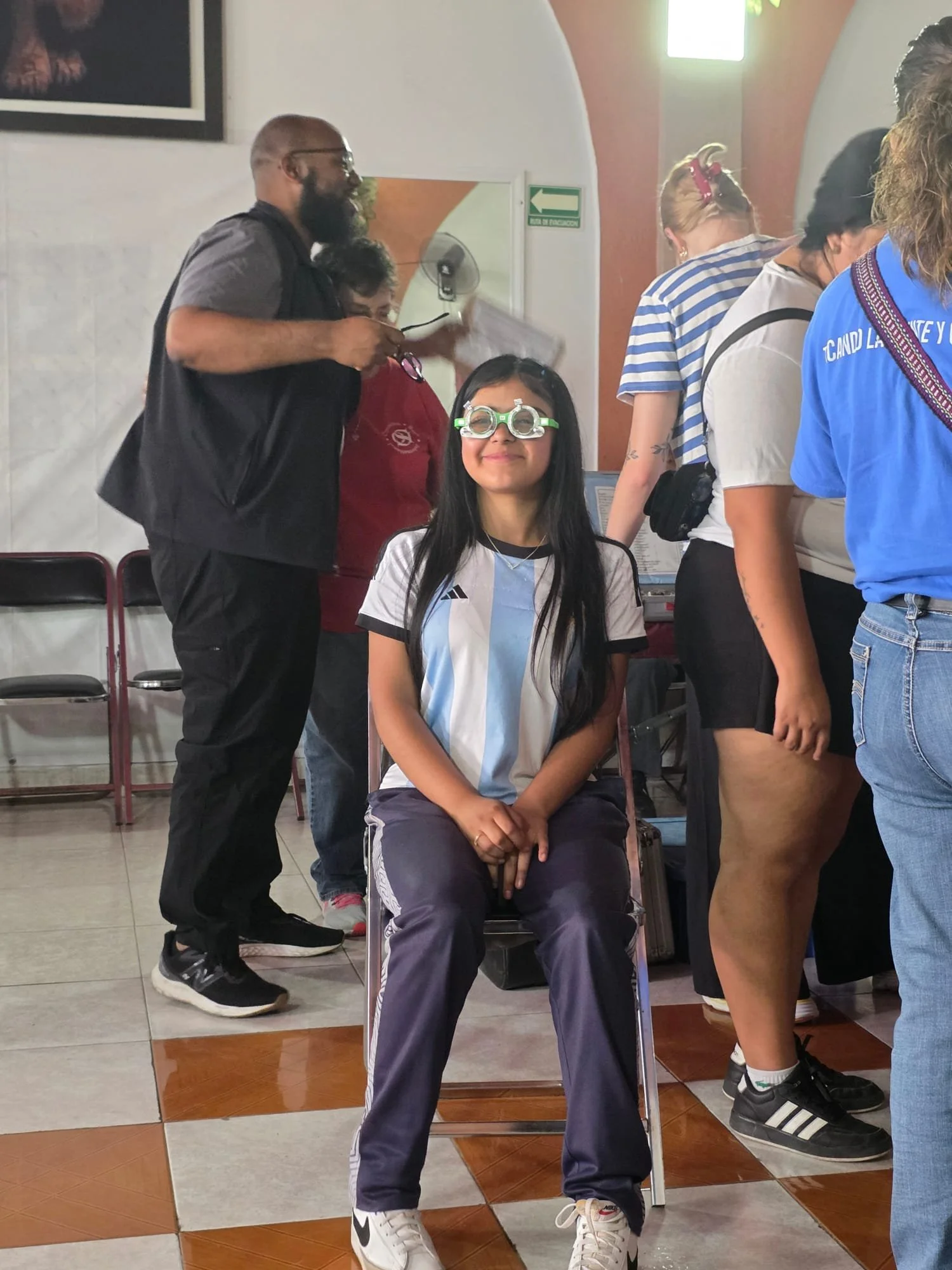 Young girl smiling while participating in a vision screening during a community medical outreach.