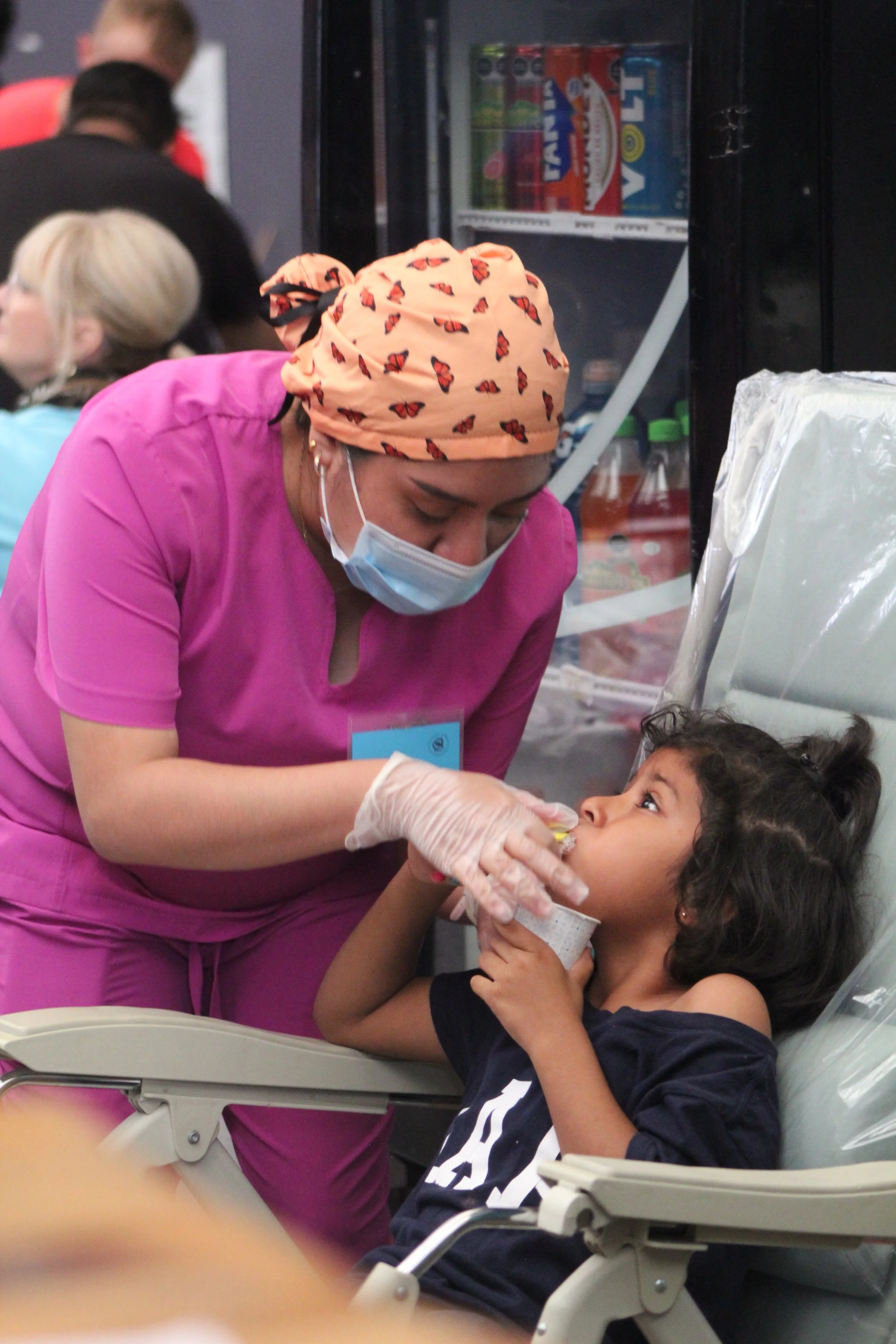 Dental volunteer providing care and comfort to a young child during a community dental clinic.