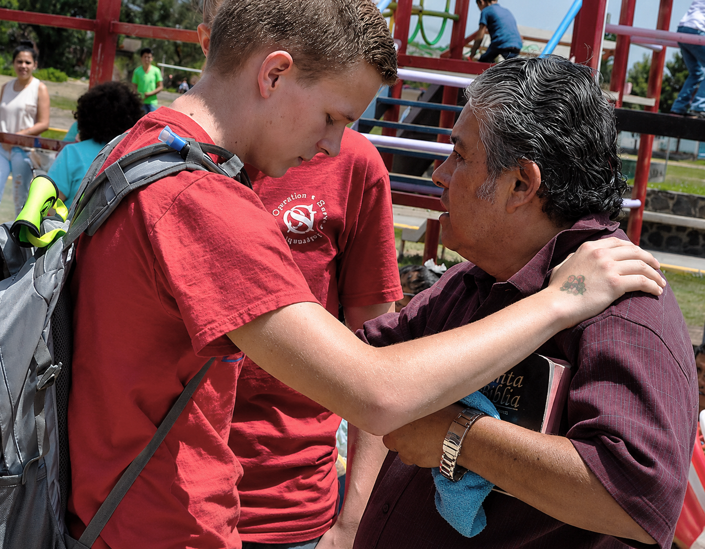 Volunteer praying with a local community member during an Operation Serve International outreach.