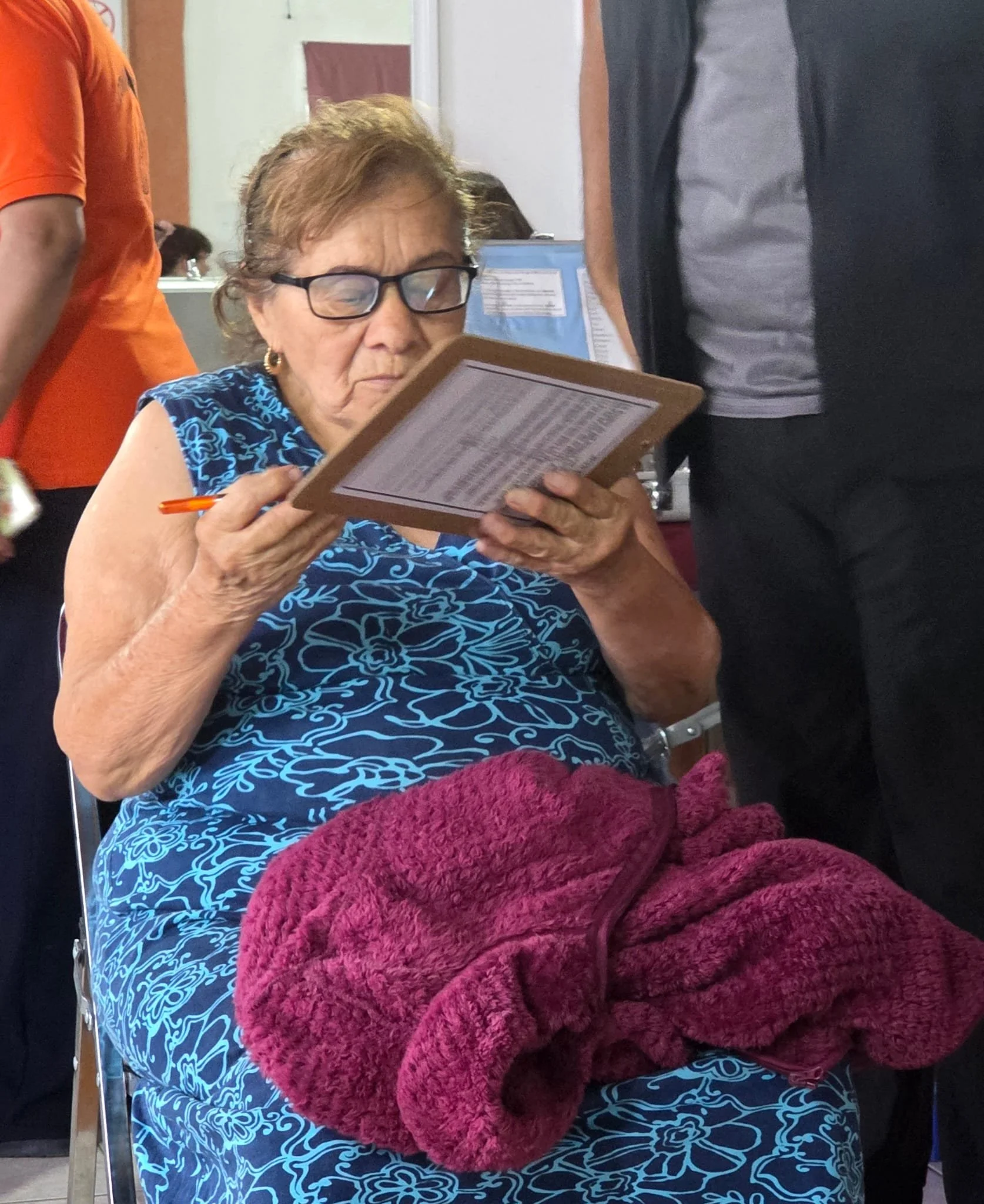 Woman completing paperwork for her new pperscription during an Operation Serve International vision screening.