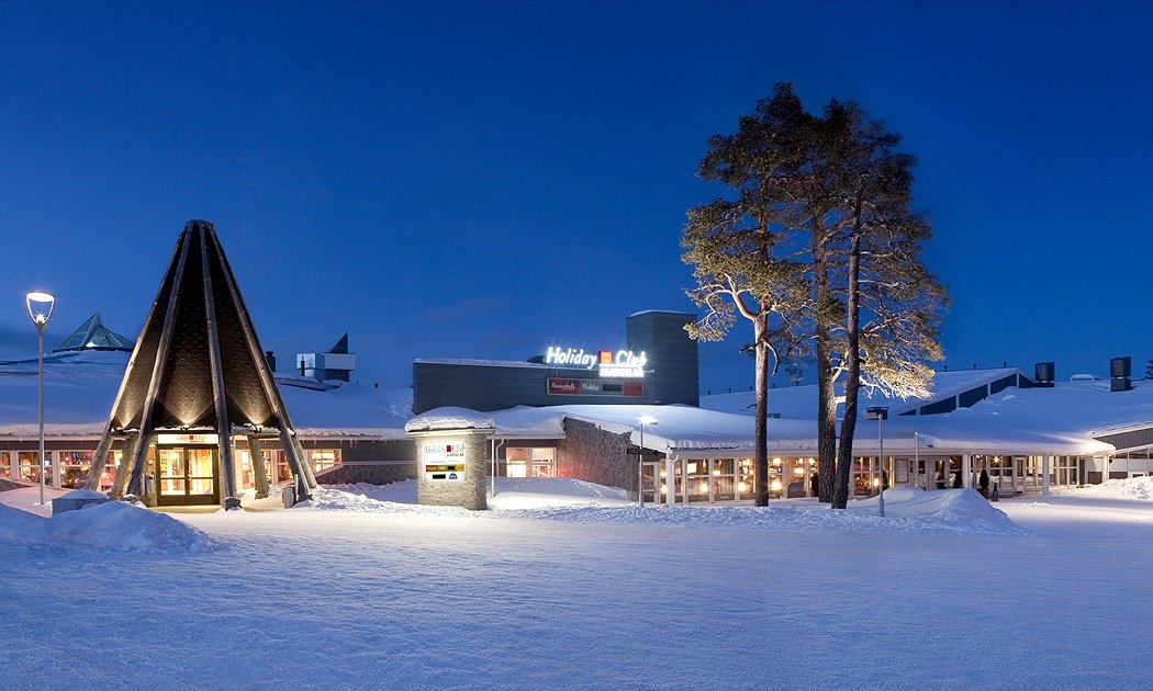 Holiday Club Saariselkä resort lit up on a snowy winter evening, aurora tour pickup point