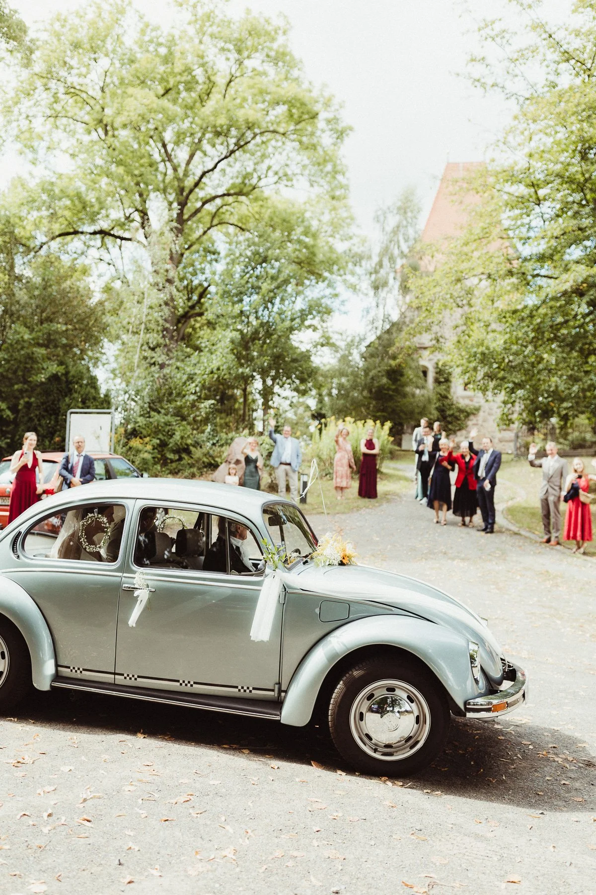 Alter Käfer als Brautauto vor Gästen