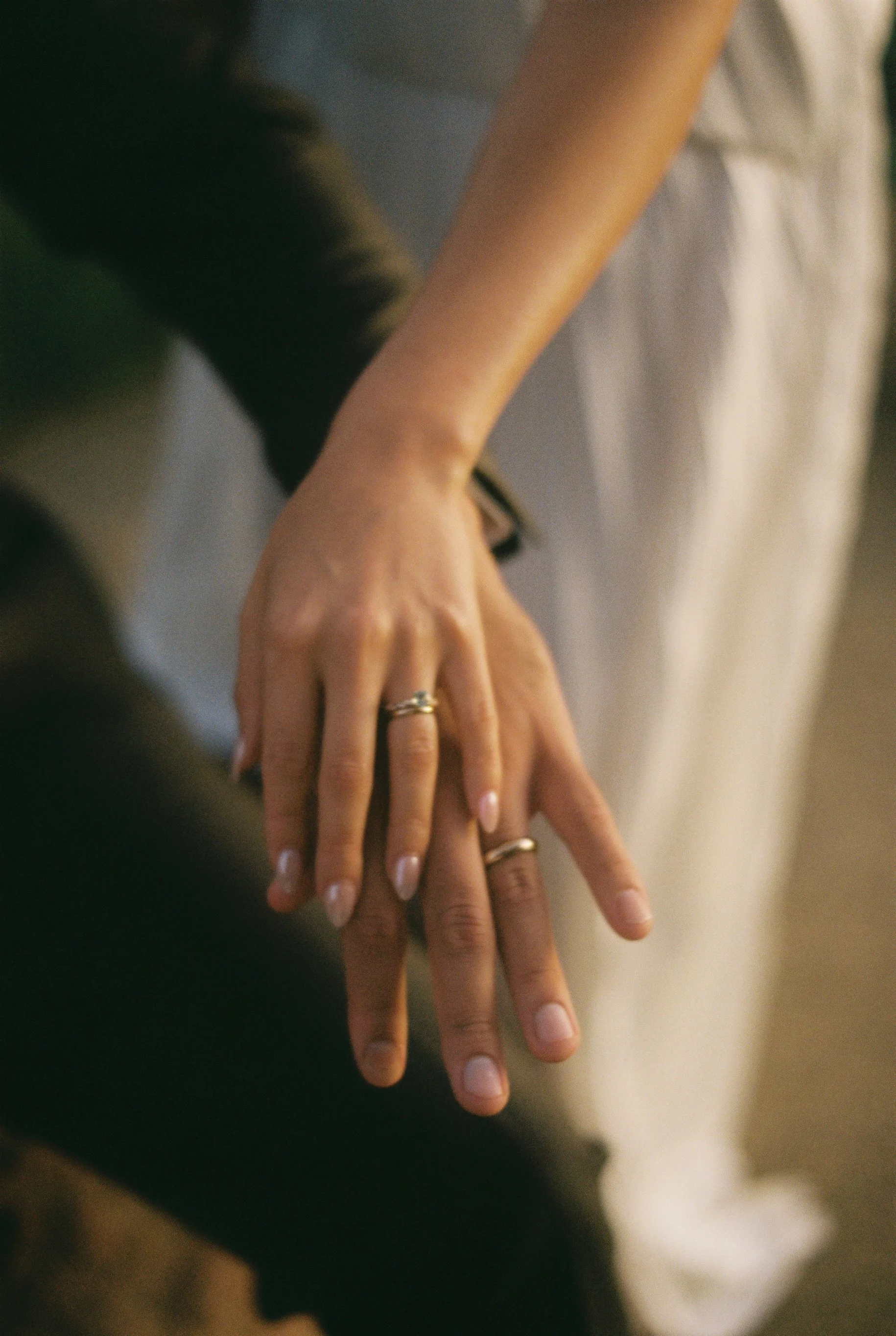Close-up of hands with rings resting on each other.