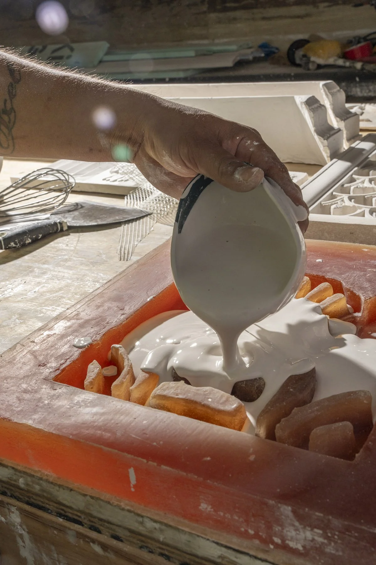 Photography of an artisan pouring plaster documenting the historic renovation of the Waldorf Astoria New York